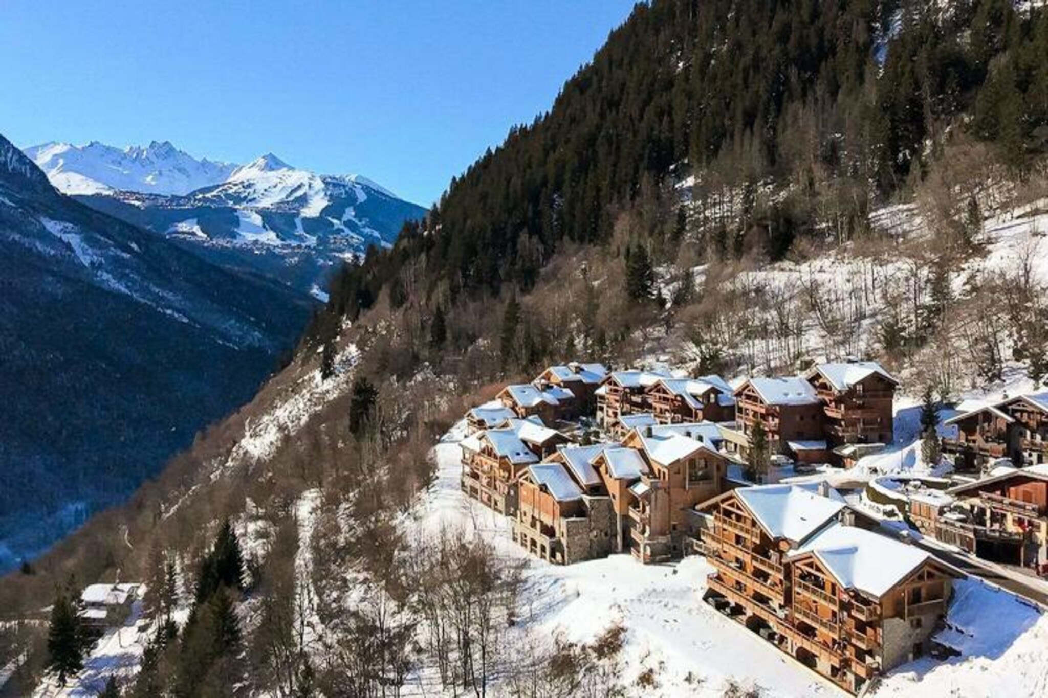 Perched at the entrance of the charming village of Champagny-en-Vanoise, Les Alpages de Champagny offers a serene alpine retreat surrounded by breathtaking natural beauty. With its south-facing orientation, the residence boasts panoramic views of the majestic Vanoise massif and the renowned Courchevel slopes, creating an idyllic backdrop for your mountain getaway. The residence is a harmonious blend of traditional chalet architecture and modern comforts, nestled within six spacious chalets that exude warmth and elegance. Whether you’re seeking adventure or relaxation, this is the perfect base for your alpine escape.
Inside, the premium duplex apartment spans two floors and accommodates up to eight guests. The thoughtfully designed layout includes three cozy bedrooms, a master suite with an en-suite bathroom, and a bright living area that opens onto a sunny balcony. The fully equipped kitchen, complete with an island, invites you to prepare hearty meals after a day on the slopes. Modern amenities such as Wi-Fi, a private garage, and ski lockers ensure convenience, while the included bed and bath linens and end-of-stay cleaning add a touch of luxury. Guests also enjoy complimentary access to the residence’s indoor pool, gym, and spa facilities, including a hammam and sauna, making it easy to unwind after an active day.
A free shuttle service operates every eight minutes during winter, connecting you to the heart of the resort, the cable car, and the ESF ski school. Beyond skiing, the area offers endless opportunities for exploration, from hiking trails to picturesque villages. Whether you’re soaking in the views from your balcony or indulging in a massage at the on-site salon, Les Alpages de Champagny promises an unforgettable alpine experience. Book your stay and discover the magic of the French Alps in every season.
