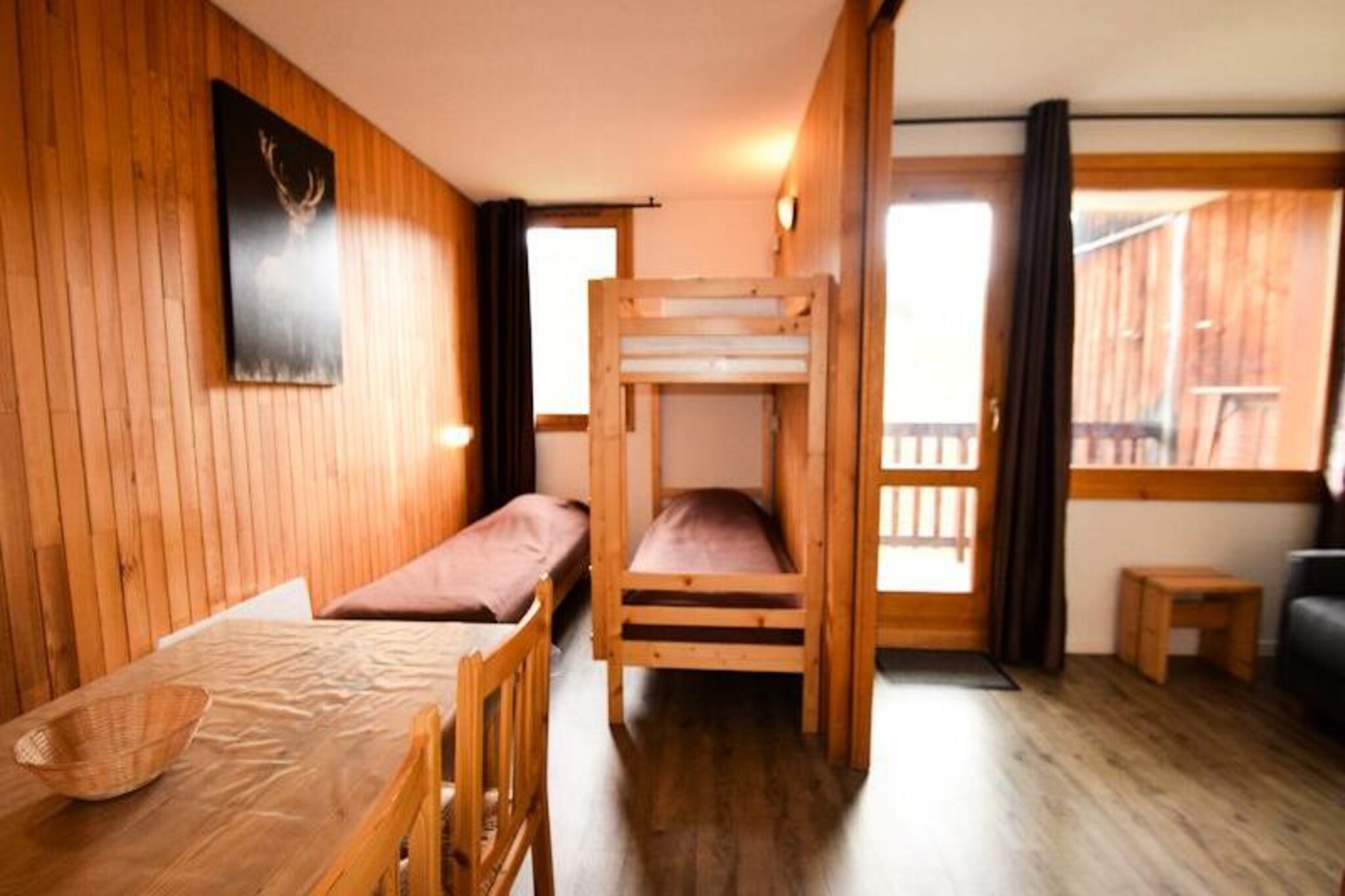 High above the serene slopes of Plagne Villages, this charming studio apartment offers a cozy retreat for ski enthusiasts and mountain lovers alike. With its south-facing balcony overlooking pristine pistes, you’ll wake up to breathtaking views and the promise of adventure just steps away. The residence’s quiet atmosphere and direct access to the slopes make it an ideal base for exploring the world-renowned Paradiski domain, whether you’re carving through fresh powder or enjoying sunny alpine trails. \n\nCompact yet thoughtfully designed, this divisible studio comfortably accommodates up to five guests. The living area features a rapido double sofa bed and a dining space, while the sliding partition reveals a separate sleeping area with bunk beds and a single bed. A well-equipped kitchen includes electric hobs, a refrigerator, microwave, and dishwasher, ensuring all the essentials for preparing hearty meals after a day on the slopes. Modern conveniences like WiFi and a ski locker on the ground floor add to the ease of your stay. \n\nLocated just 700 meters from local shops, accessible via a free shuttle bus, the residence offers both tranquility and convenience. Plagne Villages is seamlessly connected to Plagne Centre by a free gondola, making it easy to explore the wider area. In winter, enjoy unparalleled skiing, while summer transforms the region into a haven for hiking, biking, and breathtaking nature excursions. \n\nWhether you’re seeking thrilling descents or peaceful alpine vistas, this studio invites you to experience the magic of the French Alps in comfort and style.