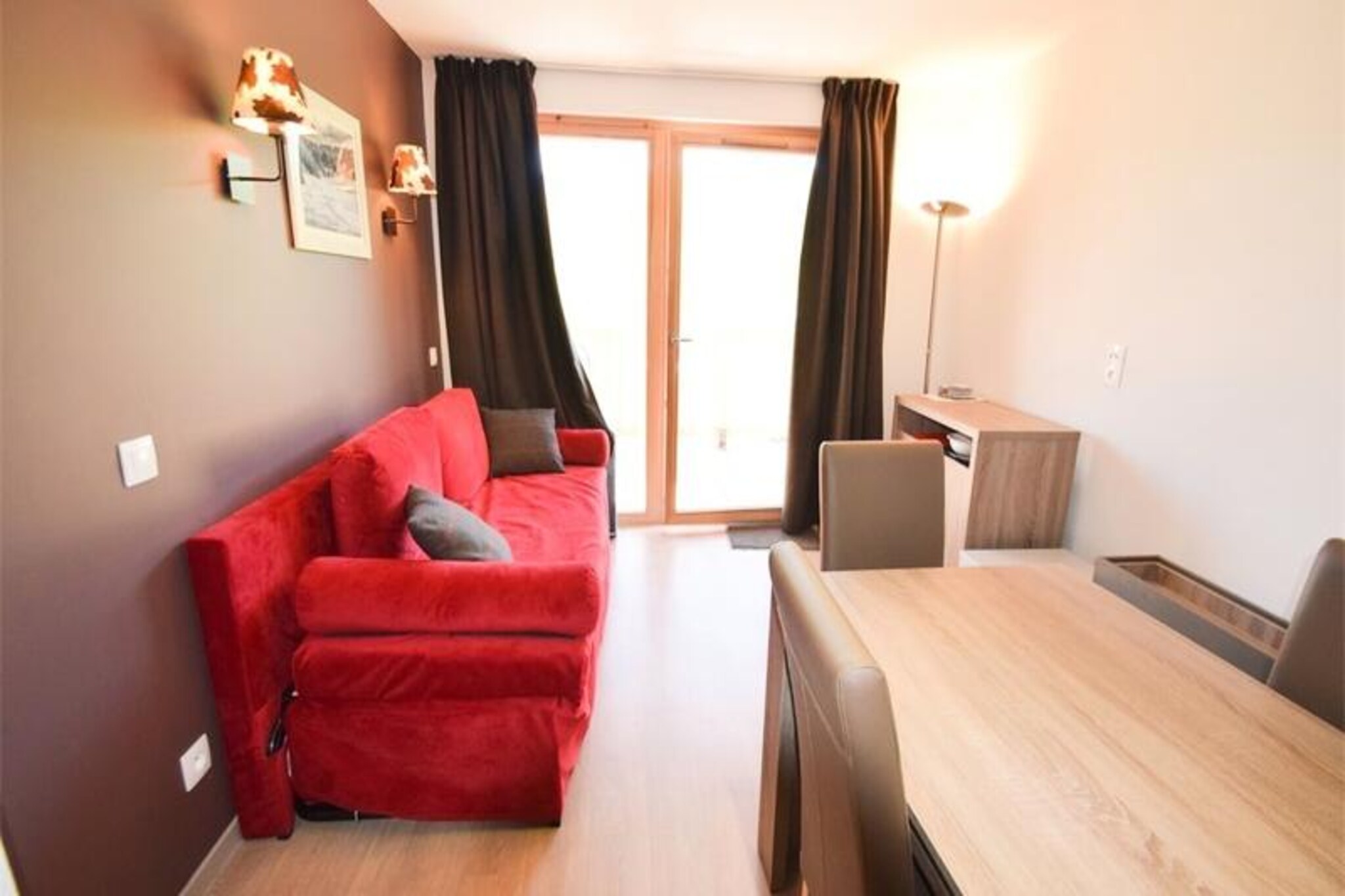 High above the picturesque slopes of La Plagne Villages, this modern alpine apartment offers a serene retreat with direct ski-in/ski-out access to the pristine pistes of the Paradiski domain. Wake up to the crisp mountain air and panoramic views of snow-covered peaks from your north-east facing balcony, where the beauty of the Alps unfolds before you. Whether you're here for winter sports or summer hikes, this residence immerses you in the heart of alpine adventure. \n\nDesigned to accommodate up to six guests, the apartment combines two interconnected spaces: a two-room unit and an adjoining studio. Together, they offer two fully equipped kitchenettes, two bathrooms, and cozy sleeping arrangements including a double bed and pull-out beds. The living areas are thoughtfully furnished with dining spaces and lounge corners, perfect for unwinding after a day of exploration. Modern amenities such as Wi-Fi, flat-screen TVs, and a ski locker ensure convenience, while the residence’s heated indoor pool adds a touch of luxury to your stay. \n\nLocated at the foot of the slopes, the property is just steps from local shops, restaurants, and essential services, making it an ideal base for your alpine getaway. In winter, enjoy effortless access to world-class skiing, while summer transforms the area into a haven for hiking, mountain biking, and nature walks. Nearby attractions include the Vanoise National Park and the charming village of Bourg-Saint-Maurice, offering a taste of local culture and cuisine. \n\nWhether you seek thrilling adventures or tranquil moments surrounded by breathtaking scenery, this apartment promises an unforgettable stay in the French Alps. Let the magic of La Plagne Villages captivate you all year round.
