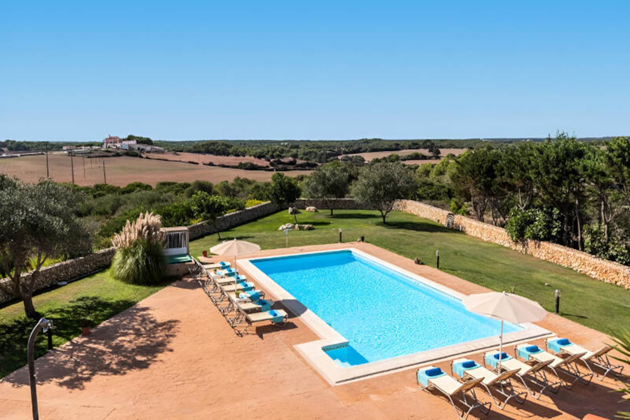 In the serene countryside of Cala Galdana, this exquisite villa offers a luxurious retreat for families or groups of up to 12 guests. Surrounded by lush gardens and just a short drive from some of Menorca’s most stunning beaches, this property is a haven of tranquility and Mediterranean charm. Whether you’re seeking a peaceful escape or an adventure-filled getaway, this villa provides the perfect setting for unforgettable memories. \n\nSpanning 326 m², the villa boasts six spacious bedrooms, each thoughtfully designed for comfort and relaxation. The bright and airy interiors are complemented by modern amenities, including air conditioning, Wi-Fi, and satellite TV in multiple languages. The fully equipped kitchen, featuring a ceramic hob, dishwasher, and coffee maker, invites you to prepare delicious meals to enjoy on the terrace overlooking the garden. Outside, the private pool and barbecue area offer endless opportunities for relaxation and al fresco dining under the Menorcan sun. \n\nLocated just 4 km from the sandy shores of Cala Galdana, the villa is ideally positioned to explore the island’s natural beauty. Nearby, you’ll find the pristine beaches of Cala Mitjana, Cala Macarella, and Cala Trebaluger, each offering crystal-clear waters and breathtaking landscapes. The charming town of Ferreries, with its local markets and traditional eateries, is only 2 km away, while the historic city of Ciutadella and the vibrant capital Mahón are within easy reach. \n\nWhether you’re lounging by the pool, exploring Menorca’s picturesque coastline, or savoring local delicacies, this villa promises an exceptional holiday experience. Discover the perfect blend of comfort, elegance, and island charm in this idyllic retreat.