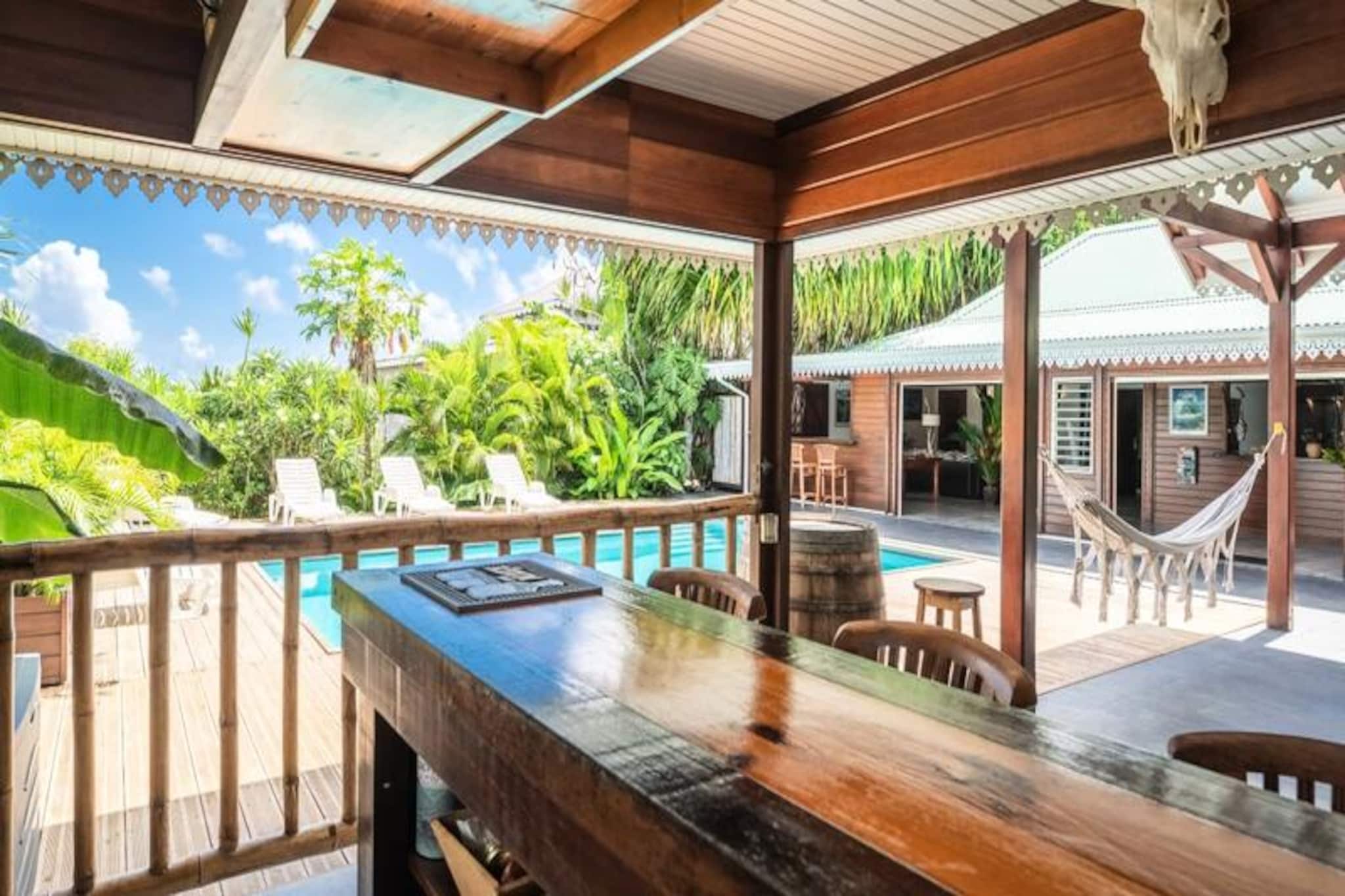 Amidst the serene sugarcane fields of Anse-Bertrand, Villa Catalunya offers an idyllic retreat infused with Caribbean charm. Here, the gentle rustle of the cane fields and distant sea views of Montserrat and Antigua set the stage for a tranquil escape. From the moment you arrive, you’ll be greeted with warm hospitality, local cocktails, and a promise of unforgettable relaxation under the tropical sun. This 3-star wooden villa blends authentic Caribbean architecture with modern comforts, creating a haven of peace and privacy.
Spanning 118m², Villa Catalunya accommodates up to six guests in three air-conditioned bedrooms, each designed for restful nights with plush 140 and 160 cm beds. The fully equipped kitchen opens onto a spacious living and dining area, perfect for sharing meals and laughter. Step outside to discover your private saltwater pool, secured for safety, where refreshing dips await at any hour. The outdoor bar, barbecue, and pétanque court invite you to savor leisurely afternoons and evenings under the stars. A traditional Caribbean bed and an outdoor shower add unique touches to this tropical sanctuary.
Located just 9 km from the renowned Port Louis surf spot, Villa Catalunya is perfectly positioned to explore the northern treasures of Grande-Terre. The rolling sugarcane fields and nearby coastal gems immerse you in Guadeloupe’s natural beauty, while the village of Anse-Bertrand offers all essential amenities within a short drive. Whether you’re seeking adventure or serenity, this villa is your gateway to an authentic island experience.
With high-speed Wi-Fi, efficient air conditioning, and a dedicated concierge service, every detail has been thoughtfully arranged for your comfort. From personalized excursions to tailored itineraries, Villa Catalunya ensures a seamless and enriching stay. Let this tropical paradise be the backdrop to your most cherished memories in Guadeloupe.