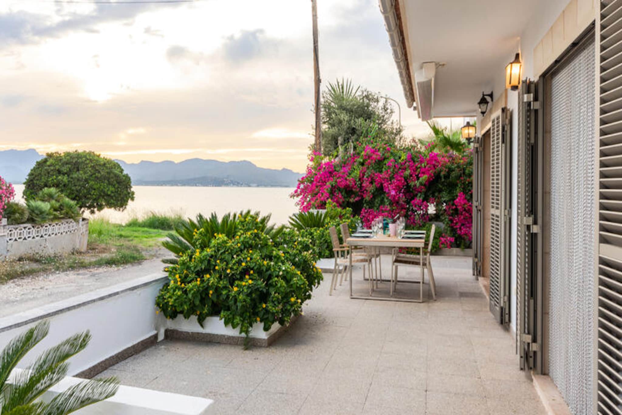 Wake up to the gentle sound of waves and the scent of the sea at this enchanting villa in Manresa, Alcudia. Just 20 steps from the beach, this idyllic retreat offers a serene escape where the Mediterranean becomes your backyard. The villa’s peaceful surroundings and breathtaking views make it the perfect haven for families or groups of up to seven guests seeking a blend of relaxation and adventure. Whether you’re sipping coffee on the terrace or enjoying a sunset barbecue, every moment here feels like a postcard come to life. \n\nInside, the villa is a harmonious blend of modern comfort and coastal charm. The bright and airy living-dining room is perfect for gathering with loved ones, complete with satellite TV, a CD player, and air conditioning in every room to ensure year-round comfort. The fully equipped gas kitchen invites culinary creativity, while the separate laundry room adds convenience to your stay. With four well-appointed bedrooms—two with single beds and two with double beds, including one with an en-suite bathroom—there’s ample space for everyone to unwind. A second bathroom with a shower ensures added comfort, and families with young children will appreciate the availability of a crib and high chair upon request. \n\nNestled in the tranquil Bay of Pollença, the villa is surrounded by natural beauty and a local, authentic atmosphere. A short drive brings you to Alcudia’s vibrant markets, Roman ruins, and the pristine beaches of Muro, Can Picafort, and Formentor. Golf enthusiasts will love the proximity to Alcanada Golf, while history buffs can explore the rich cultural heritage of the area. For dining and entertainment, the nearby Port of Alcudia offers a lively promenade, exquisite Mediterranean cuisine, and exciting water sports. \n\nWhether you’re seeking a peaceful retreat or an adventure-filled getaway, this villa offers the best of Mallorca’s coastal charm. Create unforgettable memories in this Mediterranean paradise, where every detail is designed for your comfort and delight.
