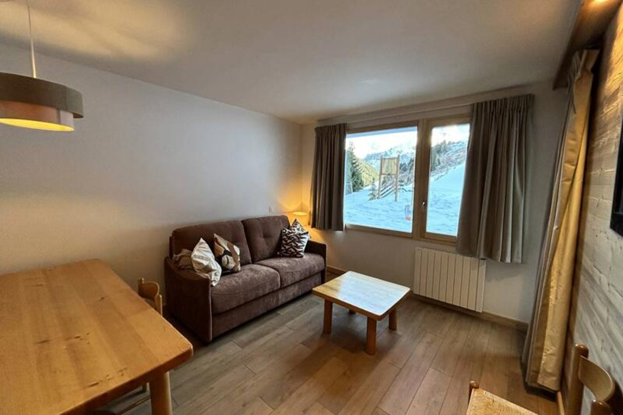 High above the picturesque Méribel Mottaret, this charming alpine apartment offers a cozy retreat for those seeking the perfect ski getaway. Imagine mornings filled with crisp mountain air and evenings spent gazing at the snow-covered peaks from your private terrace. Located in the heart of the Laitelet district, this residence combines the tranquility of the mountains with the convenience of being just steps from the slopes and local amenities. \n\nThe apartment is thoughtfully designed to accommodate up to six guests. The living room features a comfortable double sofa bed and a TV for relaxing after a day on the slopes. The bedroom includes two single beds that can be joined together and a bunk bed, making it ideal for families or small groups. The fully equipped kitchen boasts a ceramic hob, microwave, dishwasher, oven, refrigerator, kettle, toaster, and a Nespresso Essenza coffee maker, ensuring you have everything needed to prepare hearty meals. A bathroom with a separate toilet adds to the convenience, while a ski locker in the residence keeps your gear secure. Please note, this is a non-smoking property, and pets are not allowed.\n\nLe Nantchu residence is perfectly situated for ski enthusiasts, offering direct access to the slopes and proximity to shops, restaurants, and bars. The free Méribus shuttle or the Les Chalets cable car provides easy access to the center of Mottaret, where you can explore more of what this vibrant resort has to offer. \n\nWhether you're here to carve through pristine snow or simply soak in the serene alpine atmosphere, this apartment is your gateway to unforgettable mountain adventures. Book your stay and experience the magic of Méribel Mottaret firsthand.