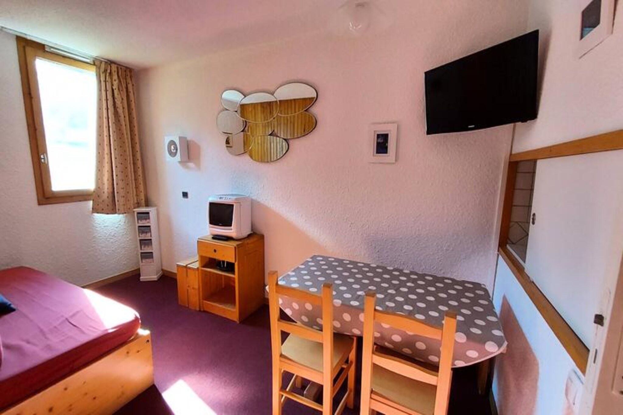 At the edge of the picturesque Crève Coeur hamlet in Valmorel, this charming studio apartment offers a cozy alpine retreat with direct access to the slopes just steps away. Imagine waking up to the serene beauty of the French Alps, stepping onto your south-facing balcony to take in unobstructed views of the surrounding peaks, and heading straight into a day of thrilling skiing adventures. The residence, Le Gollet, exudes traditional Savoyard charm with its stone and wood construction, blending seamlessly into the mountain landscape. Whether you're here for winter sports or summer hikes, this location offers the perfect base for your alpine escape. \n\nThe apartment is thoughtfully furnished for comfort and practicality. The kitchen is fully equipped with an electric hob, dishwasher, oven, microwave, and refrigerator, making it easy to prepare meals after a day on the slopes. The divisible living room features a sofa bed with a trundle bed and two single sofa beds, ensuring flexible sleeping arrangements for up to four guests. A separate bathroom and toilet provide added convenience, while the south-facing balcony invites you to relax and soak in the mountain air. Ski lockers are available in the residence, making it effortless to store your gear. Please note that Wi-Fi is not included, and the apartment is non-smoking and not accessible to guests with reduced mobility. Additional services such as end-of-stay cleaning, bed linen, and towels can be reserved in advance. \n\nCrève Coeur hamlet is ideally situated, offering easy access to the resort center and the Mottet hamlet via the Télébourg cable car. Nearby, you'll find essential shops including a bakery, mini-market, and sports store, ensuring all your needs are met during your stay. Paid parking is conveniently located at the foot of the residence. Guests consistently praise this apartment for its comfort and location, with an average rating of 7.79/10. \n\nWhether you're seeking the thrill of skiing, the tranquility of alpine hikes, or simply a peaceful retreat surrounded by breathtaking scenery, this studio apartment in Valmorel promises an unforgettable mountain getaway.