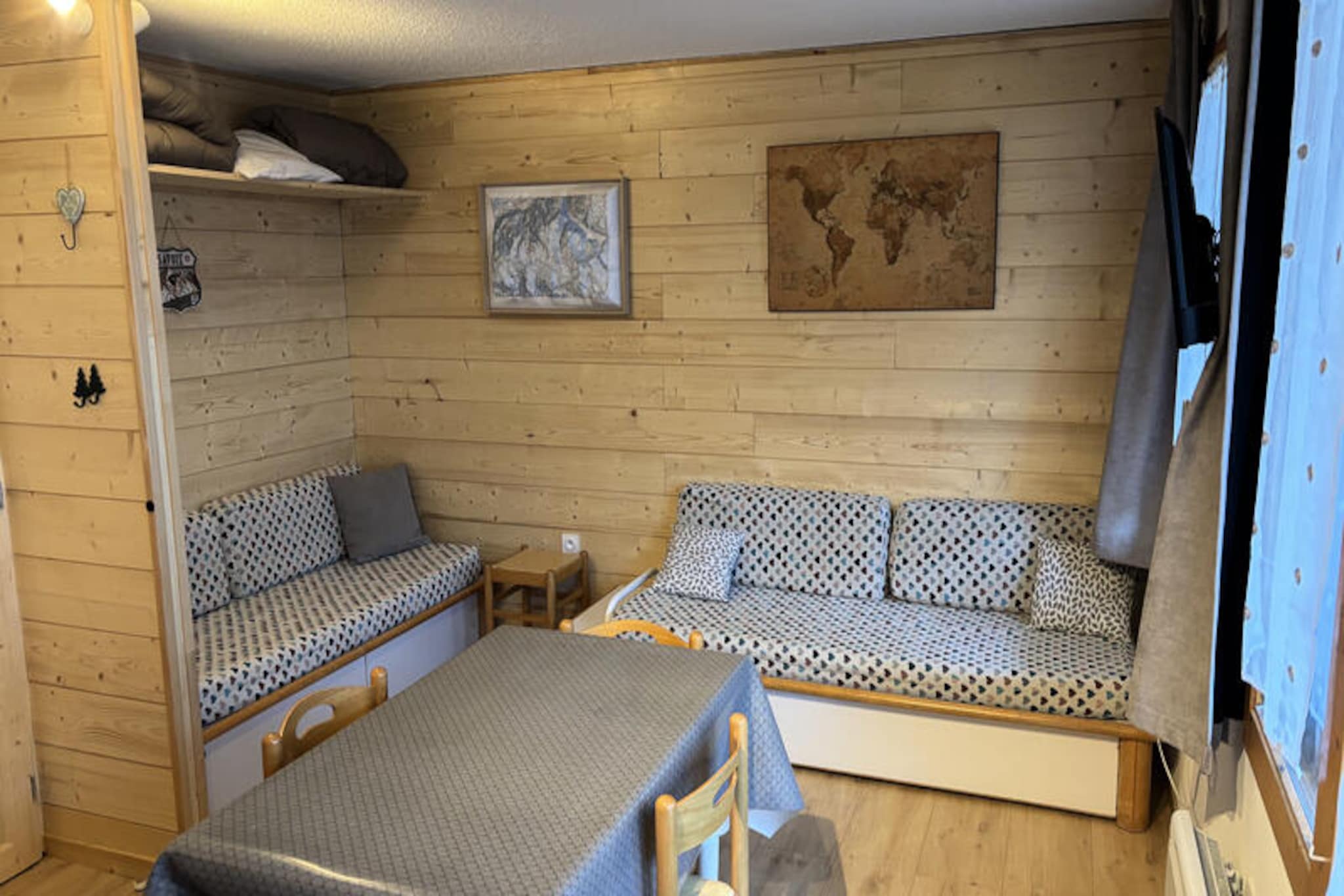 Surrounded by the serene beauty of Les Coches, this charming studio cabin offers a cozy retreat for adventurers and nature lovers alike. Imagine waking up to the gentle rustle of fir trees outside your south-facing terrace, where the morning sun bathes the landscape in golden light. Whether you're here for thrilling days on the slopes or tranquil evenings in the heart of the Alps, this ground-floor studio promises a memorable stay in one of France's most picturesque mountain destinations. Fully renovated in 2024, the property combines modern comfort with alpine charm. \n\nInside, you'll find a thoughtfully designed space featuring a fully equipped kitchen with ceramic hob, dishwasher, microwave, oven, and electric coffee maker—perfect for preparing hearty meals after a day of exploration. The sleeping arrangements include a cozy alcove with bunk beds (not suitable for children under 6) and two single beds in the main living area, ensuring a restful night for up to four guests. The bathroom, complete with a bathtub and toilet, adds a touch of relaxation, while the flat-screen TV provides entertainment for quiet evenings. A ski locker is conveniently available, making it easy to store your gear after a day on the slopes.\n\nLocated just 200 meters from the shops and ski slopes, the residence offers unparalleled convenience. The ski lift ticket office and resort center are mere steps away, ensuring you can maximize your time on the mountain. Free public parking and an elevator add to the ease of your stay, while the peaceful surroundings create a perfect balance of accessibility and tranquility. \n\nWhether you're visiting for winter sports or summer hikes, this studio cabin is your gateway to the enchanting landscapes of Les Coches. With its blend of comfort, location, and alpine charm, it’s the ideal choice for creating unforgettable memories in the French Alps.