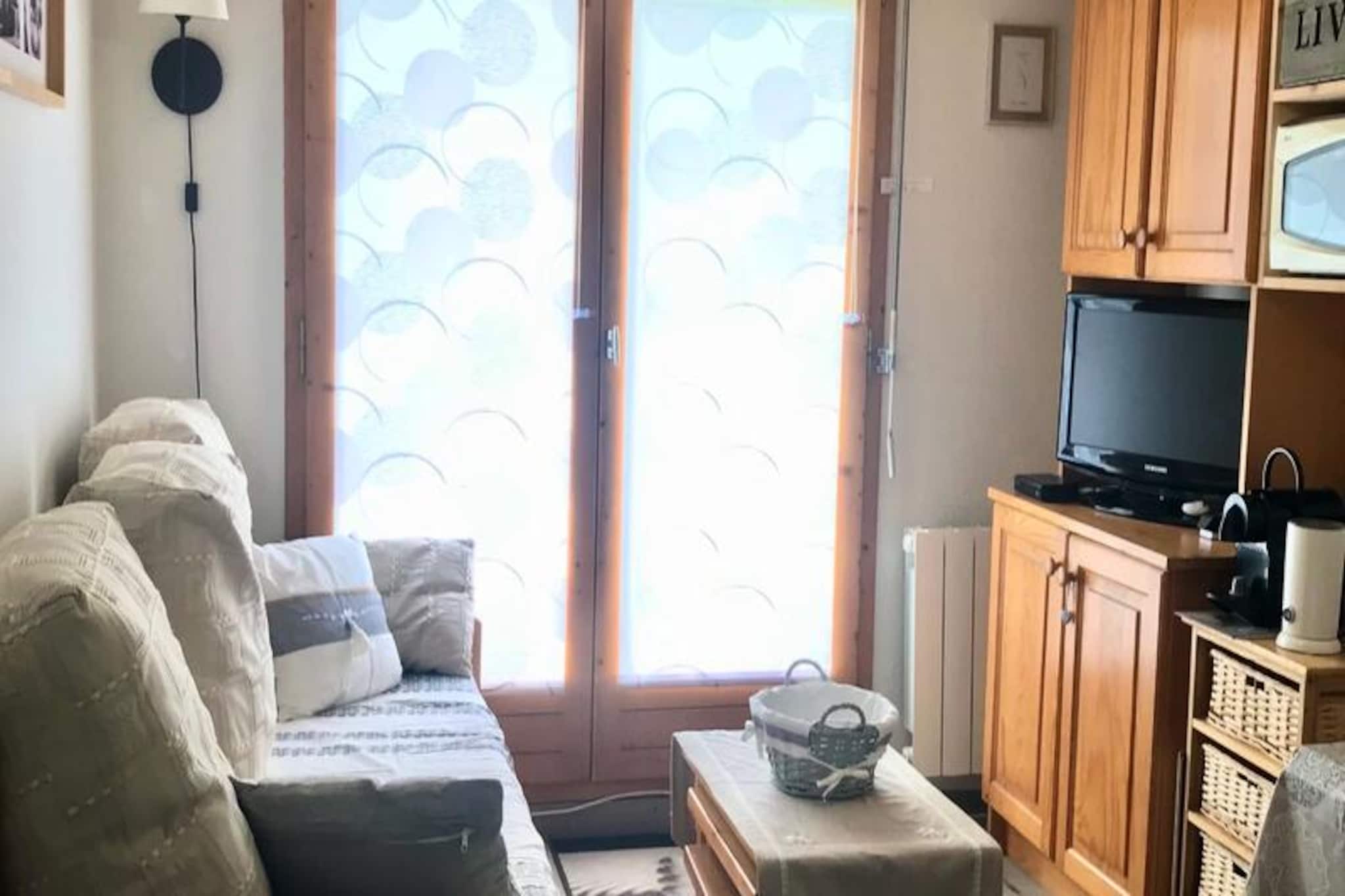 Beneath the shimmering peaks of the French Alps, this charming ground-floor apartment offers a seamless blend of comfort and convenience for your mountain getaway. With direct access to the slopes, you can step outside and begin your alpine adventures without delay. Whether you're here to carve through fresh powder in winter or explore scenic trails in summer, this residence places you at the heart of it all. The balcony provides a front-row seat to breathtaking views of the slopes, inviting you to savor the crisp mountain air each morning. \n\nInside, the apartment has been thoughtfully renovated to ensure a cozy and functional stay for up to four guests. The bright living room, complete with a dining area, sofa, and flat-screen TV, is perfect for relaxing after an active day. The open kitchen is equipped with modern appliances, including a refrigerator, mini oven, microwave, dishwasher, and coffee makers, making it easy to prepare meals. The sleeping alcove features bunk beds, while the separate bedroom offers a comfortable double bed, TV, and DVD player for added entertainment. The bathroom includes a bathtub for unwinding, and a private ski locker ensures your gear is always within reach. \n\nSituated in the \