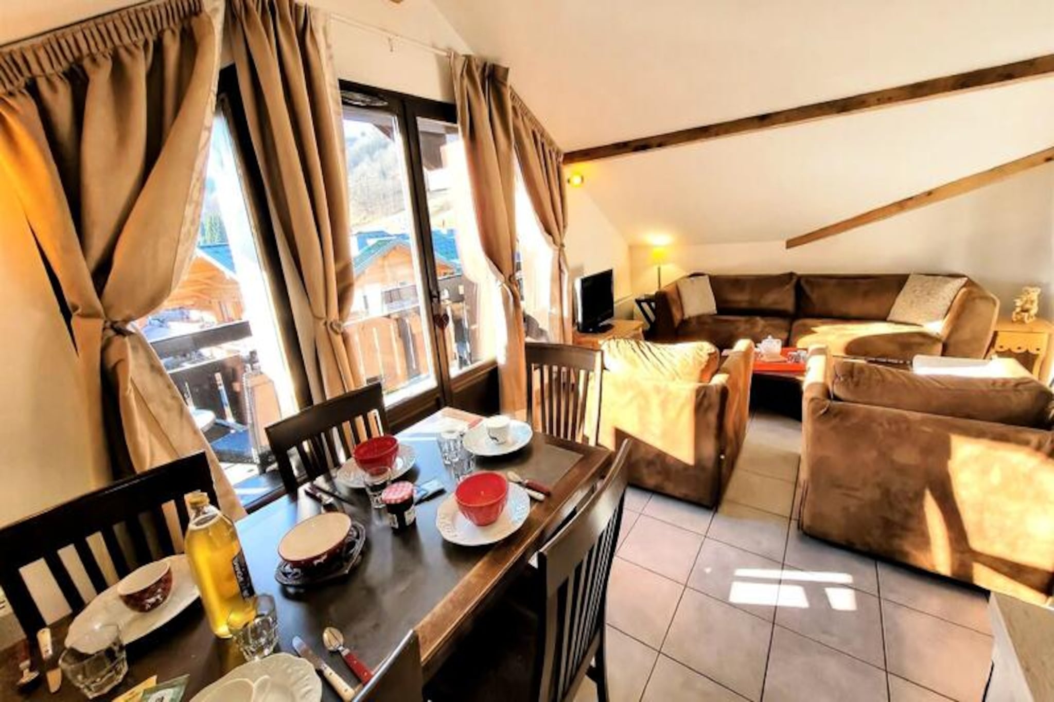 High above the picturesque French Alps, this luxurious top-floor apartment offers a perfect blend of comfort and elegance, promising an unforgettable mountain retreat. Bathed in sunlight thanks to its southwest exposure, the residence boasts breathtaking views of the surrounding peaks from its private balcony, creating the ideal setting for relaxation after a day of adventure. Whether you're here for winter sports or summer hikes, the serene atmosphere and refined amenities will make every moment special. \n\nInside, the apartment is thoughtfully designed to accommodate up to eight guests, making it ideal for families or groups of friends. The spacious living room, complete with a cozy sofa, TV, and dining area, opens onto a fully equipped kitchen featuring modern appliances such as a dishwasher, Senseo coffee machine, and raclette set for authentic alpine evenings. Three bedrooms offer flexible sleeping arrangements, including an en-suite double bedroom and two rooms with single beds that can be joined upon request. Two bathrooms, one with a bathtub and heated towel rail, ensure comfort and convenience for all guests. \n\nThe residence itself is a haven of relaxation, featuring heated indoor and outdoor pools and a spa area. A ski locker, locked garage, and covered parking space add practicality to your stay. Located just 450 meters from the nearest ski slopes and 400 meters from the village center, you'll find everything you need within easy reach, including shops, restaurants, and the ESF ski school. In summer, explore scenic trails or unwind in the wellness area after a day of discovery. \n\nWith linens, towels, and end-of-stay cleaning included, this property ensures a carefree holiday experience. Whether you're seeking thrilling alpine adventures or tranquil moments surrounded by nature, this residence is your gateway to the magic of the French Alps.