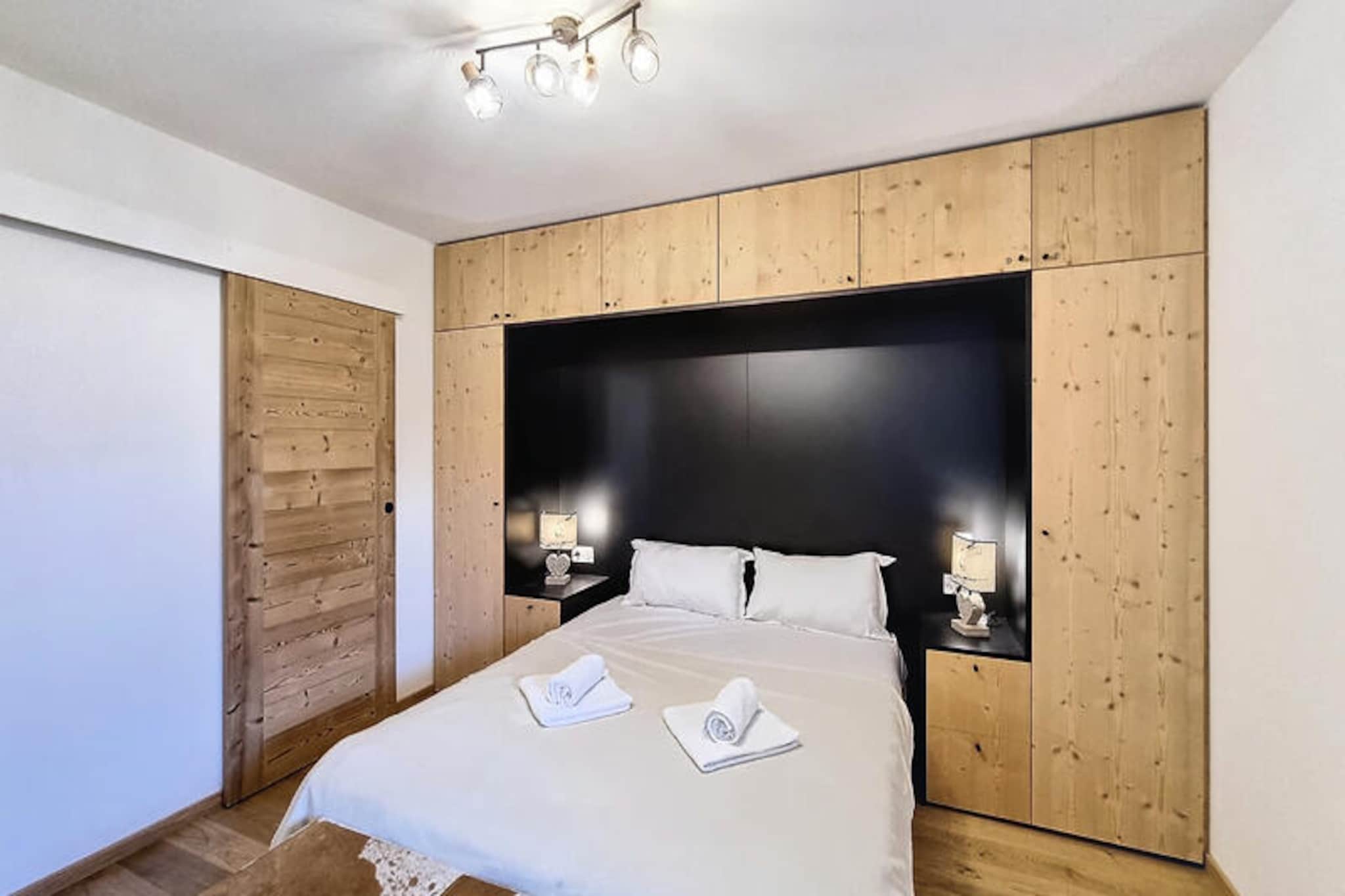 In the heart of the charming alpine village of Les Gets, this contemporary 2-bedroom apartment offers a perfect blend of modern comfort and mountain charm. Just a short stroll from the vibrant town center, it provides an ideal retreat for up to eight guests, whether you're seeking a winter wonderland or a summer escape. The residence’s prime location ensures easy access to the ski lifts and the lively amenities of Les Gets, making it a haven for outdoor enthusiasts and leisure seekers alike. \n\nStep inside and discover a beautifully designed 70 m² space, where every detail has been thoughtfully curated for your comfort. The bright and airy living area opens onto a fully equipped kitchen, complete with high-end appliances such as an oven, stovetop, refrigerator, and dishwasher. Gather around the cozy dining area for shared meals, or relax in the inviting living room with plush sofas and a flat-screen TV. The apartment’s balcony offers stunning mountain views, perfect for soaking in the serene alpine atmosphere. Modern bathrooms with walk-in showers and a dedicated ski locker add to the convenience, ensuring a seamless stay in every season.\n\nBeyond the apartment, Les Gets awaits with its array of attractions. In winter, the ski lifts are just moments away, granting access to the expansive Portes du Soleil ski area. During the warmer months, the village transforms into a hub for hiking, mountain biking, and exploring the breathtaking landscapes of the French Alps. The town center brims with charming shops, cozy cafes, and gourmet restaurants, offering a taste of authentic Savoyard culture.\n\nWhether you're carving through snowy slopes, wandering through alpine meadows, or simply unwinding in the comfort of this elegant apartment, your stay in Les Gets promises unforgettable memories. Experience the magic of the mountains in every season from this exceptional home away from home.