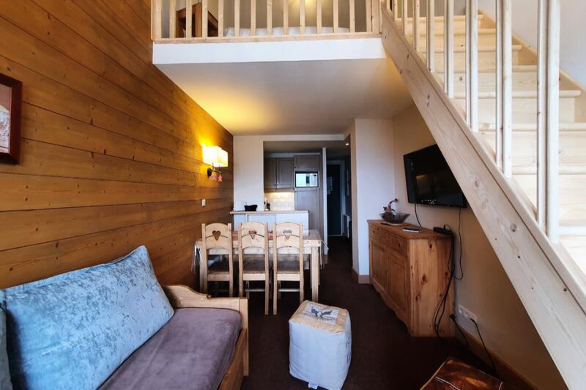 At the edge of a serene alpine forest, this charming apartment offers a peaceful retreat with breathtaking views of Mont Blanc from its north-facing balcony. Perfectly situated for ski enthusiasts, the residence provides ski-in/ski-out access to Montchavin’s slopes, ensuring effortless days on the powdery trails. Whether you’re seeking adventure or relaxation, this property invites you to immerse yourself in the natural beauty of the French Alps. \n\nSpanning 65 m², this 2-star apartment accommodates up to eight guests across its thoughtfully designed layout. Upstairs, you’ll find a mezzanine with two single beds, a cozy windowless bedroom with two single beds, and a compact shower room. On the ground floor, there’s a double bedroom with a TV, another bedroom with two single beds, and a spacious living area featuring a TV and a fully equipped open-plan kitchen. The kitchen includes modern appliances such as a refrigerator/freezer, dishwasher, microwave, ceramic hobs, and a Senseo coffee maker. Additional conveniences include a washing machine, dryer, and ski locker, ensuring a comfortable and practical stay. \n\nThe residence itself is nestled near the slope leading to Montchavin, with a shuttle bus stop conveniently located for easy access to the resort center. Its traditional architecture, blending wood, stone, and slate, complements the picturesque surroundings. In addition to skiing, guests can explore nearby trails, enjoy the tranquility of the forest, or simply marvel at the panoramic valley views. \n\nWhether you’re visiting for a winter ski holiday or a summer escape, this apartment offers the perfect base for creating unforgettable memories in the heart of the Alps. With its blend of comfort, convenience, and stunning scenery, it’s an ideal choice for families and groups alike.