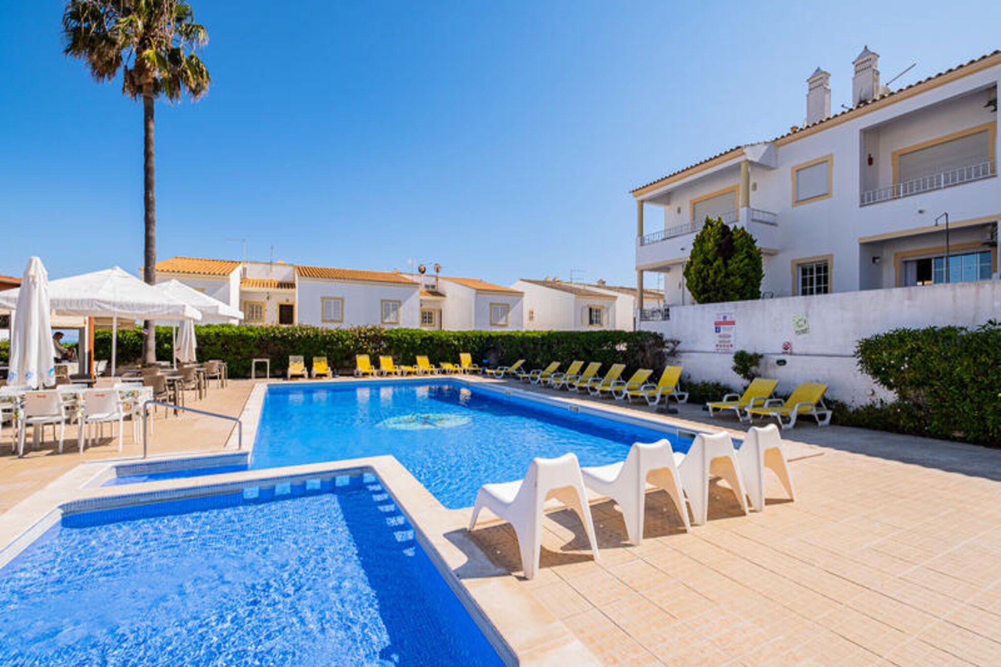 Just a short stroll from the golden sands of São Rafael Beach, this charming apartment offers a serene retreat in one of Albufeira’s most sought-after locations. Surrounded by lush greenery and nestled within a peaceful condominium, this property invites you to unwind and savor the tranquil beauty of Portugal’s Algarve coast. Whether you’re soaking up the sun on your private terrace or enjoying a barbecue under the stars, every moment here feels like a true escape from the everyday.
Inside, the apartment is thoughtfully designed to provide both comfort and convenience. The fully equipped kitchen makes meal preparation a breeze, while the air-conditioned interiors ensure a pleasant stay year-round. The balcony overlooking the pool is perfect for keeping an eye on the kids or simply enjoying a quiet moment with a coffee. Families will appreciate the child-friendly amenities, including a dedicated children’s pool and activities in the complex. For those seeking a bit of activity, a tennis court is available, and the Casa Vela Pool Bar and Restaurant offers delicious meals at reasonable prices.
The location is unbeatable. São Rafael Beach and Praia dos Arrifes are both within a 10-minute walk, while Albufeira’s Old Town, with its vibrant shops, bars, and restaurants, is just a 5-minute drive away. The nearby marina and local grocery stores add to the convenience, and a bus stop within walking distance connects you to the city’s main attractions. Whether you’re exploring the Algarve’s stunning coastline or simply relaxing by the pool, this apartment offers the perfect base for an unforgettable holiday.
With private parking, pet-friendly options, and the possibility of arranging airport transfers, this property caters to all your needs. Escape the hustle and bustle and discover the perfect blend of relaxation and adventure in this idyllic Algarve retreat.