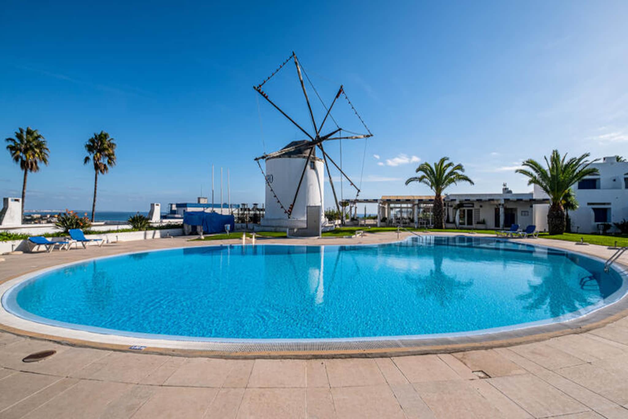 With breathtaking views of Albufeira’s charming old town, this beautifully renovated apartment offers a serene escape in the sought-after Alto do Moinho condominium. Imagine waking up to the gentle sea breeze, stepping out onto your sunlit terrace, and enjoying the tranquil ambiance of lush gardens and sparkling pools. Perfectly situated within walking distance of Albufeira’s historic center and golden beaches, this property combines convenience with a peaceful retreat. Whether you’re seeking relaxation or adventure, this is the ideal base for your Algarve getaway. \n\nThe apartment, located on the ground floor, comfortably accommodates up to five guests with two bedrooms, including an en-suite, and a sofa bed. Its thoughtful design spans two levels, with the upper floor featuring a fully equipped kitchen, a cozy bedroom, and a bathroom. The lower level boasts a spacious living room with a fireplace and French doors leading to the south-facing terrace, complete with a barbecue and outdoor seating. The terrace offers stunning views of the pool, gardens, and even glimpses of the sea. Modern amenities such as heating ensure comfort year-round, while the cool interiors provide respite during warmer days. \n\nGuests can enjoy the condominium’s exceptional facilities, including a large swimming pool, tennis court, and a restaurant housed in a restored windmill with panoramic views. The on-site mini-market and bar add convenience, while the private parking ensures ease of access. For those seeking adventure, the nearby beaches, vibrant nightlife, and historic landmarks of Albufeira are just minutes away. \n\nWhether you’re lounging by the pool, exploring the cobbled streets of the old town, or savoring fresh seafood at a local restaurant, this apartment offers a perfect blend of comfort, charm, and location. Create unforgettable memories in this Algarve haven, where every moment feels like a dream come true.
