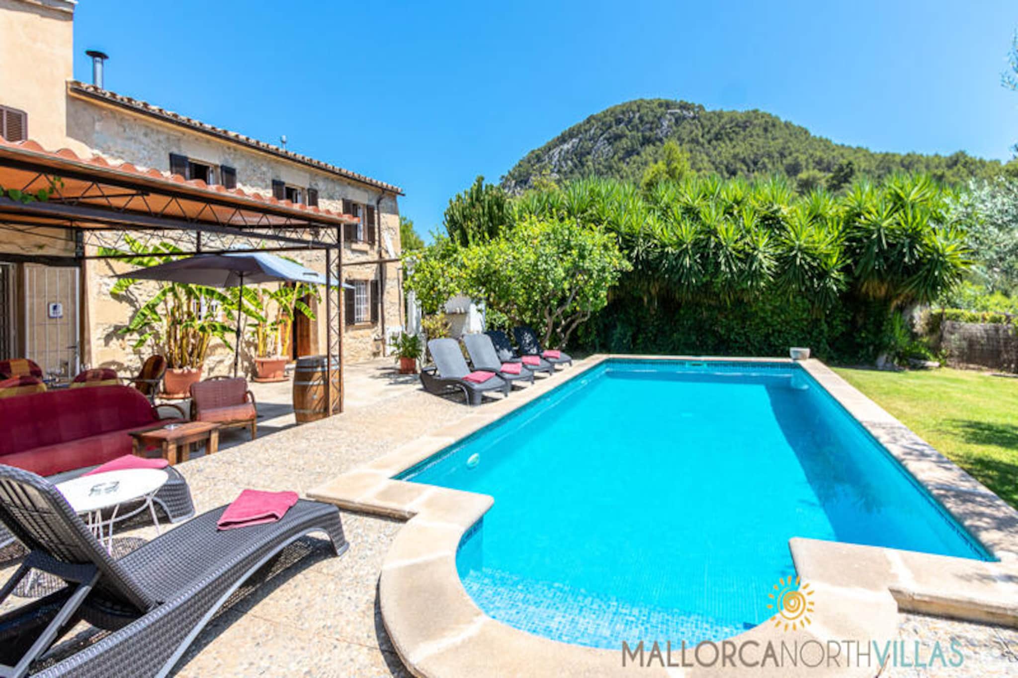 Amid the serene beauty of Mallorca’s countryside, this charming family villa offers a perfect retreat just 1 km from the historic heart of Pollensa. Imagine strolling through cobbled streets, exploring vibrant markets, and savoring local delicacies at quaint restaurants, all within walking distance. With breathtaking views of the Serra de Tramuntana and the iconic Puig de Maria, this property is a gateway to the authentic essence of Mallorca. \n\nDesigned to accommodate up to six guests, the villa features three cozy bedrooms and two bathrooms spread across two levels. The ground floor welcomes you with a bright living room complete with a fireplace, a dining area, and a fully equipped kitchen, while the upper floor houses the restful bedrooms—one with a double bed and two with single beds—each offering stunning views of the surrounding landscape. Rustic charm meets modern comfort with original wooden beams, terracotta floors, and stone walls complemented by air conditioning, free Wi-Fi, and a fireplace for cooler evenings. \n\nStep outside to discover a private oasis. The furnished terrace invites you to relax under the Mediterranean sun, while the garden’s barbecue area is perfect for al fresco dining. The highlight is undoubtedly the private pool, offering a refreshing escape on sunny Mallorca days. Whether you’re lounging poolside or enjoying a meal outdoors, the tranquility of this setting is unmatched. \n\nIdeal for families or groups of friends, this villa combines privacy, comfort, and proximity to Pollensa’s cultural and natural treasures. Book your stay now and immerse yourself in the timeless charm of Mallorca.