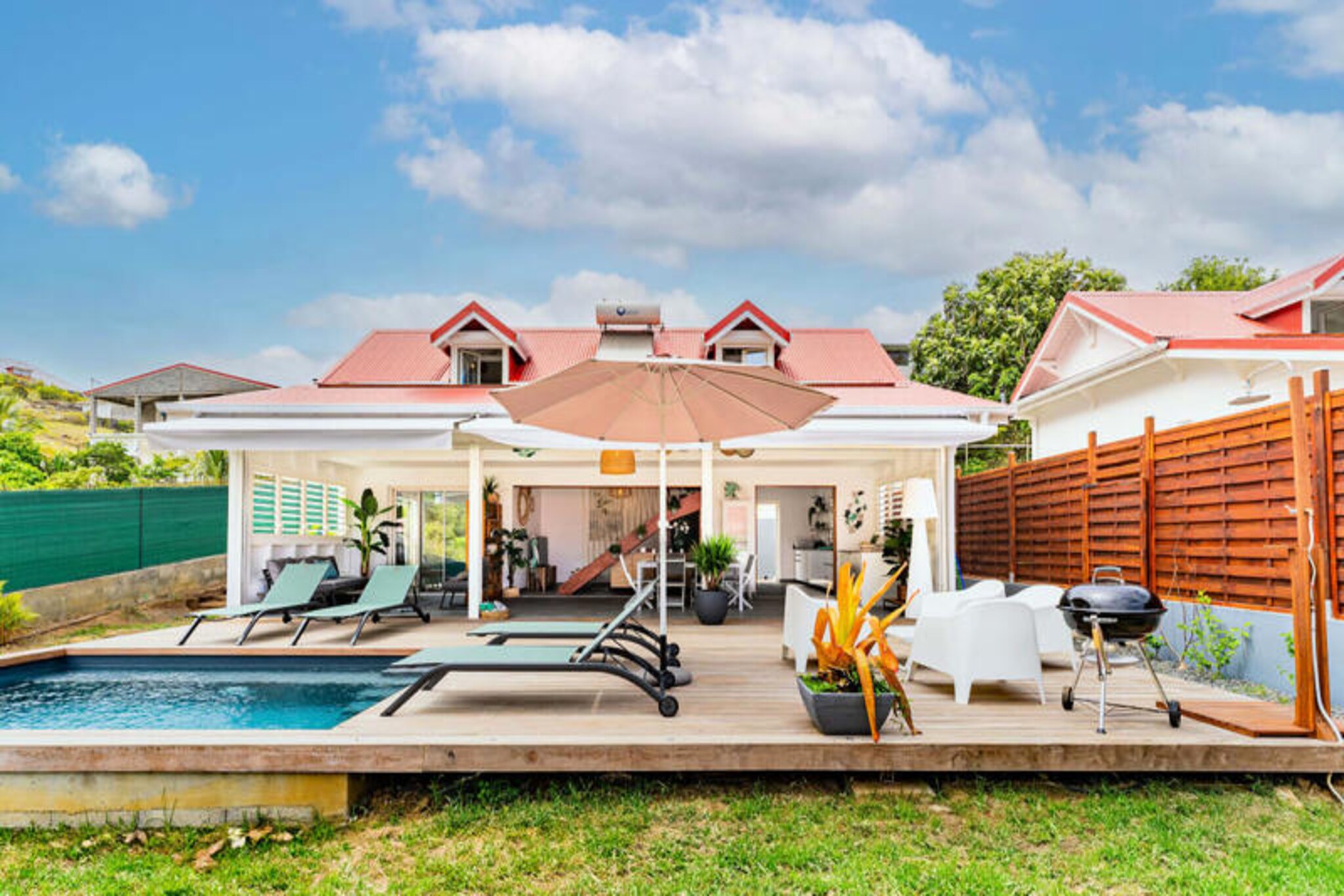On the serene island of Les Saintes, Villa Opale invites you to experience a slice of Caribbean paradise. Situated on Route de l'Anse Figuier in Terre-de-Haut, this recently built villa is bathed in gentle breezes and surrounded by lush tropical beauty. Whether you're seeking tranquility or adventure, this elegant retreat offers the perfect balance for an unforgettable getaway. Just a short stroll from local shops and restaurants, it provides easy access to the island’s vibrant culture and culinary delights. \n\nDesigned to accommodate up to six guests, with space for two additional children, Villa Opale boasts three air-conditioned bedrooms adorned with tasteful decor. The ground floor features a private bedroom with an en-suite bathroom and walk-in shower, while upstairs, two charming bedrooms share a modern bathroom and separate toilet. The fully equipped kitchen opens onto a spacious terrace, where an outdoor dining area awaits under the Caribbean sky. Beyond the terrace, a sparkling swimming pool, sun loungers, and a barbecue set the stage for relaxed afternoons and lively evenings. \n\nExplore the island at your own pace with options for car, scooter, or electric bike rentals. Discover iconic landmarks such as Fort Napoleon, the pristine Pompierre Beach, and the majestic Sugarloaf Mountain. Water enthusiasts can dive into adventures at the nearby diving club or rent kayaks just 300 meters away. For hikers, a 45-minute trek to Chameau’s summit rewards you with breathtaking sunset views over the island. \n\nVilla Opale combines comfort, elegance, and convenience, offering air conditioning, high-speed internet, and hotel-quality linens. With a dedicated concierge service ready to assist, your stay is guaranteed to be seamless and memorable. Whether you’re relaxing by the pool or exploring the wonders of Terre-de-Haut, this villa is your gateway to an enchanting Caribbean escape.