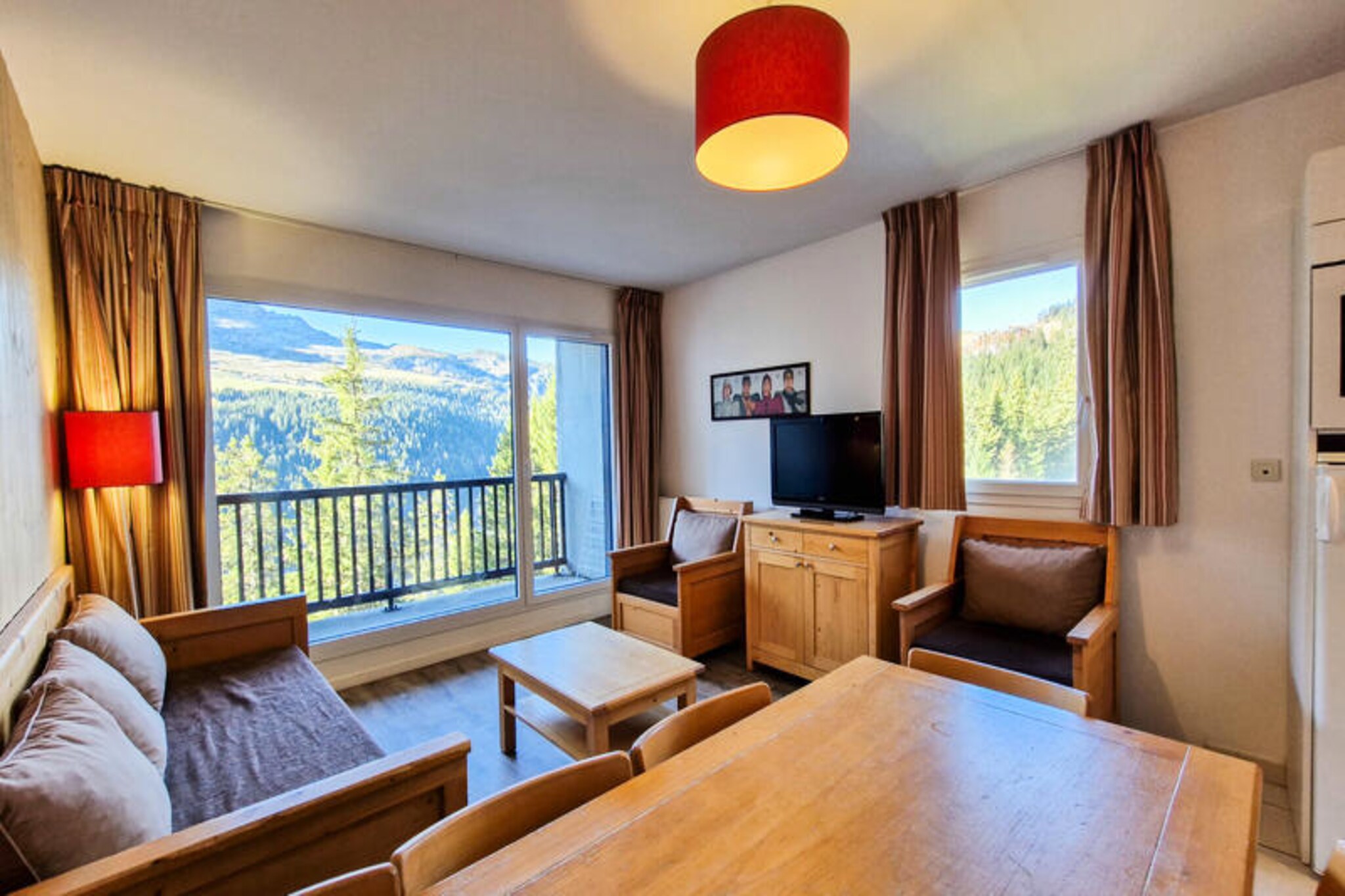 In the serene heart of Flaine Forêt, this charming three-room apartment offers a perfect blend of alpine comfort and modern convenience. Just 500 meters from the slopes and ski lifts, and a mere 150 meters from the bustling shopping mall, this residence ensures you’re never far from the action. The free ski bus stops right in front, making your mountain adventures effortless and stress-free. With a south-facing balcony, you can soak in the sun and admire the breathtaking alpine scenery from the comfort of your own space. \n\nDesigned to accommodate up to eight guests, this 60 m² apartment is thoughtfully laid out to provide both comfort and functionality. The living room features a single sofa bed with a trundle, while the two bedrooms offer a mix of single and double beds. A cozy cabin with bunk beds adds a playful touch, though it’s not suitable for children under six. The open-plan kitchen is fully equipped with a ceramic hob, multifunction oven, refrigerator, microwave, and dishwasher, making it easy to prepare hearty meals after a day on the slopes. Hardwood floors and tiled spaces add a touch of elegance, while modern amenities like a flat-screen TV with cable channels ensure relaxation. \n\nThe residence also boasts practical features such as a ski locker, on-site laundry facilities, and optional covered parking. In summer, guests staying six nights or more receive the exclusive Flaine Summer Pass, granting access to a variety of activities. Whether you’re here for winter sports or summer hikes, the location is ideal for exploring the natural beauty of the French Alps. \n\nChoose this apartment for its unbeatable location, thoughtful amenities, and the promise of unforgettable alpine memories. Whether you’re traveling with family or friends, this is the perfect base for your mountain getaway.