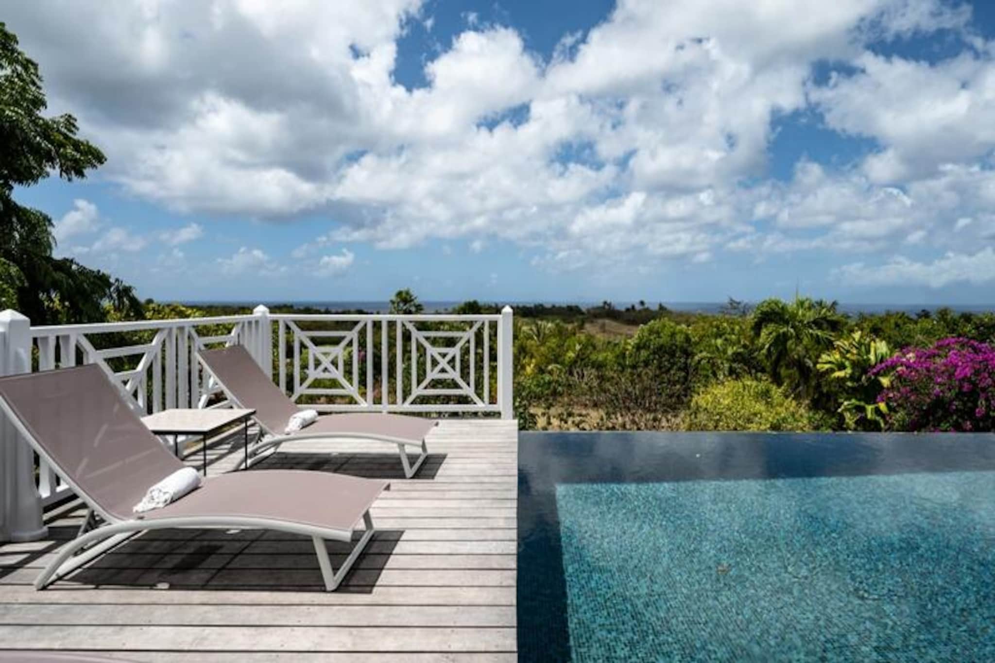On the serene island of Marie-Galante, where the turquoise Caribbean Sea meets pristine white sands, Villa Blanche offers an unparalleled escape into nature and tranquility. Hidden within a lush tropical garden teeming with banana trees and vibrant hummingbirds, this sanctuary invites you to reconnect with the simple pleasures of life. Here, the only sounds are the whispers of the breeze, the chirping of birds, and the occasional tropical rain shower, creating a setting that feels timeless and untouched.
This exquisite property accommodates up to 11 guests across five beautifully designed bedrooms, each with its own private bathroom. Two of these are nestled in independent bungalows, offering ultimate privacy, while the master suite boasts breathtaking sea views. The villa’s heart is a spacious living area that seamlessly blends indoor and outdoor living. A fully equipped Italian kitchen, shaded terrace, and an infinity pool overlooking the sea provide the perfect spaces for relaxation and connection. The one-hectare garden, dotted with fruit trees and winding paths, adds to the charm, while amenities like air conditioning, high-speed Wi-Fi, and a pétanque court ensure modern comforts.
Just five minutes from Grand-Bourg, you’ll find vibrant markets, Creole restaurants, and local distilleries to explore. The nearby beaches of Anse Canot and La Feuillère offer serene swimming and thrilling kitesurfing opportunities. Whether you’re hiking through sugarcane fields, enjoying a ti-punch on the terrace, or taking a starlit dip in the infinity pool, Villa Blanche promises an unforgettable Caribbean retreat. With a dedicated concierge service to assist with excursions, vehicle rentals, and local recommendations, your stay will be as seamless as it is magical.
Discover the essence of Guadeloupe’s natural beauty and authentic charm at Villa Blanche—a haven where luxury meets simplicity.