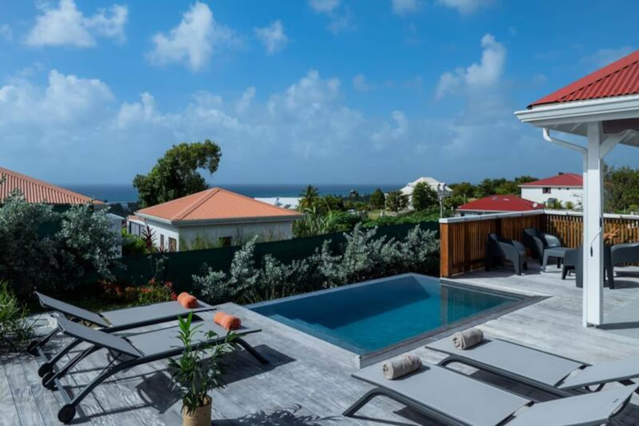 Bask in the tranquility of Villa Paloma, a serene retreat perched on the heights of Grand-Bourg, offering breathtaking views and modern comforts. This elegant villa is a haven for couples or friends seeking a peaceful escape under the Caribbean sun. With its private infinity pool seamlessly blending into the horizon, you’ll find yourself immersed in the beauty of Marie-Galante’s pristine landscapes. The villa’s design harmoniously combines contemporary luxury with the island’s natural charm, creating an atmosphere of pure relaxation.
Inside, two air-conditioned suites with queen-size beds and en-suite bathrooms provide ultimate comfort and privacy. The bedrooms, separate from the main living area, ensure a quiet and restful stay, perfect for adults traveling together. The open-plan kitchen, equipped with high-end appliances, flows effortlessly onto the terrace, where you can enjoy al fresco dining while soaking in the sea views. The living room, complete with a smart TV and fiber optic internet, offers a cozy space to unwind after a day of exploration.
Located just five minutes from the heart of Grand-Bourg, the villa is ideally situated to experience the best of Marie-Galante. Discover the island’s renowned white sand beaches, such as La Feuillère and Anse Canot, perfect for swimming and sunbathing. Explore local markets, savor Creole delicacies, or wander through the lush sugar cane fields and scenic hiking trails that define the island’s unique charm.
With personalized concierge services, including excursions, vehicle rentals, and exclusive recommendations, Villa Paloma ensures an unforgettable stay. Whether you’re lounging by the infinity pool or exploring the island’s hidden gems, this retreat promises a vacation filled with relaxation, adventure, and the warm embrace of the Caribbean.