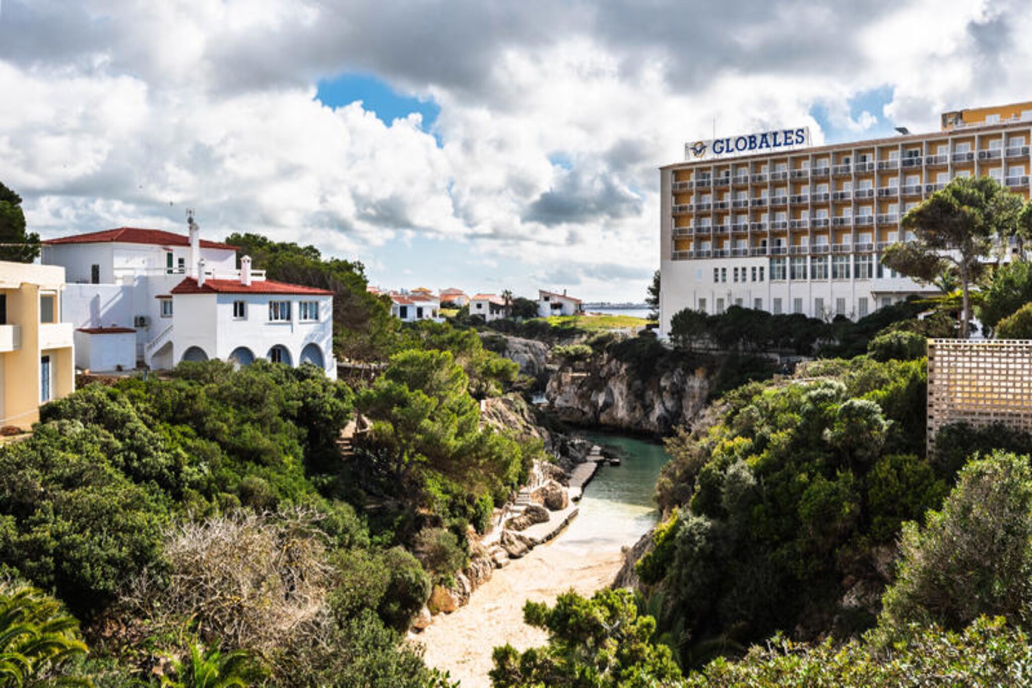Imagine a serene retreat where the gentle sound of waves and the scent of the sea greet you each morning. This charming apartment, debuting in 2025, is a cozy haven for couples or small families, offering a unique blend of comfort and modernity. Located just 200 meters from the golden sands of Cala’n Forcat beach, with direct access, it promises an idyllic escape in a tranquil coastal setting. Despite its low ceilings, the clever design and airy decor create a spacious and inviting atmosphere that feels anything but confined. \n\nInside, you’ll find brand-new furnishings, including a comfortable double bed and a sofa bed, accommodating up to four guests. The apartment is thoughtfully equipped with modern amenities such as air conditioning, heat pump heating, WiFi, and a washing machine, ensuring a hassle-free stay. The terrace, adorned with cozy furniture, invites you to unwind with a morning coffee or an evening glass of wine, while the lush garden and children’s play area add a touch of joy for families. Two sparkling community pools provide the perfect spot to cool off after a day at the beach. \n\nThe location is unbeatable, offering a peaceful atmosphere while being close to all essential amenities. Whether you’re exploring the nearby coves, enjoying local cuisine, or simply basking in the Mediterranean sun, this apartment is your gateway to an unforgettable vacation. Book your stay and be among the first to experience this delightful seaside retreat in 2025.