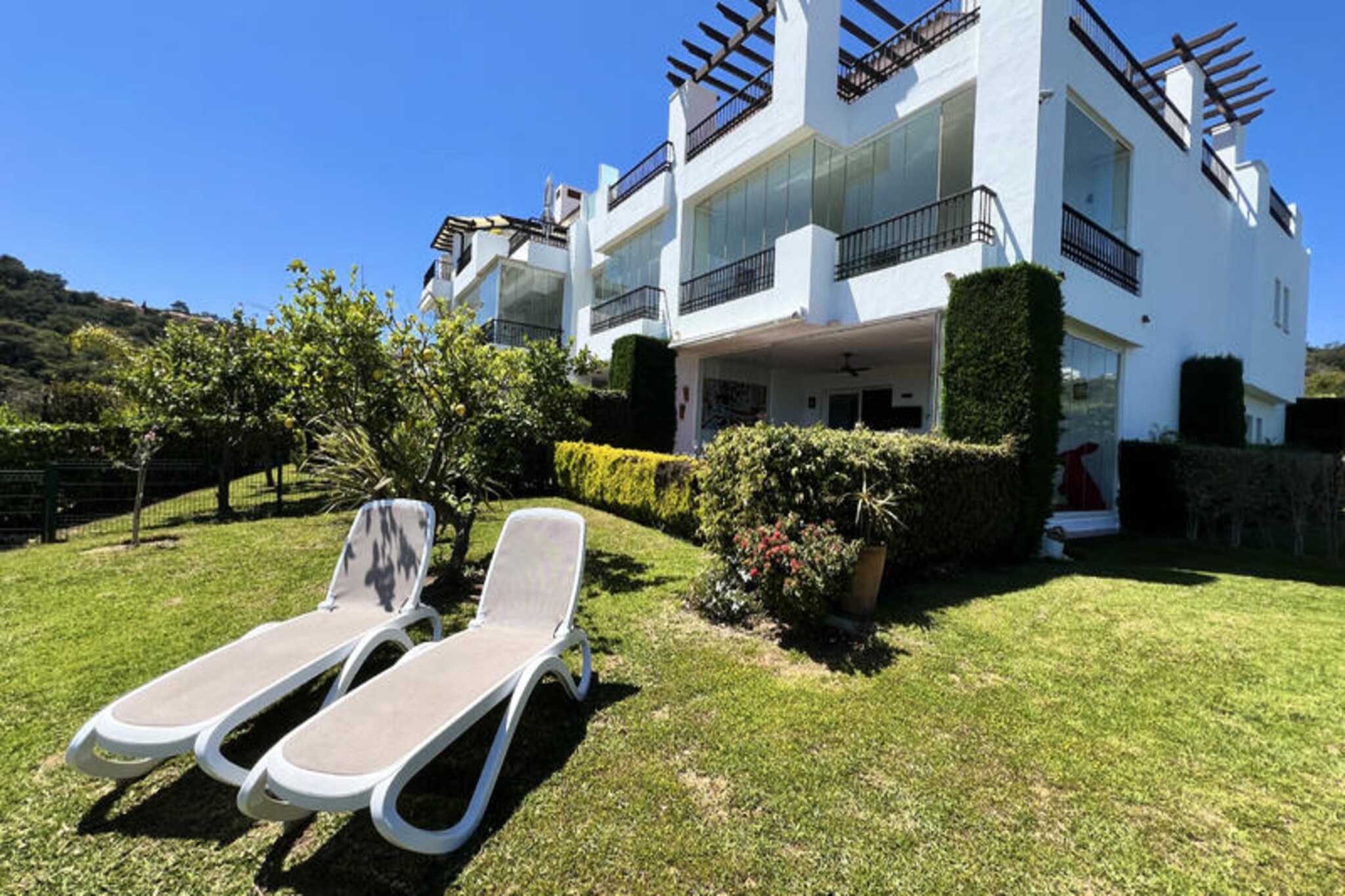 High above the sparkling Costa del Sol, this luxurious corner ground-floor apartment invites you to experience the perfect blend of tranquility and indulgence. Surrounded by the serene hills of La Mairena, this retreat offers sweeping panoramic views of the Mediterranean Sea, Marbella’s rolling landscapes, and the majestic Sierra de Las Nieves Mountains, a UNESCO Biosphere Reserve. Whether you seek a peaceful escape or an active holiday, this property promises an unforgettable stay. \n\nInside, the apartment boasts two spacious bedrooms and two modern bathrooms, designed with comfort in mind. The fully equipped kitchen is perfect for preparing meals to enjoy on the sunny outdoor terrace, complete with a BBQ for al fresco dining. A 250 m² private garden, a shaded patio, and a glass-enclosed winter terrace provide ample space to relax and soak in the breathtaking surroundings. The apartment’s thoughtful amenities include a welcome pack with essentials, ensuring a seamless start to your vacation. \n\nGuests can enjoy access to two shared swimming pools, including one for children, both offering stunning coastal and mountain views. For sports enthusiasts, the nearby El Soto Club, just two minutes away, provides complimentary access to a 9-hole golf course, fitness room, sauna, jacuzzi, pétanque court, and tennis and paddle tennis courts, with rackets available in the apartment. After an active day, unwind with a refreshing drink or a delicious meal at the club’s inviting restaurant. \n\nWith its idyllic location near some of the most beautiful beaches of the Costa del Sol, this apartment is a haven for relaxation and adventure alike. Whether you’re exploring the vibrant streets of Marbella, hiking through the nearby mountains, or simply basking in the Mediterranean sun, this is your gateway to the best of Andalusian charm and luxury.
