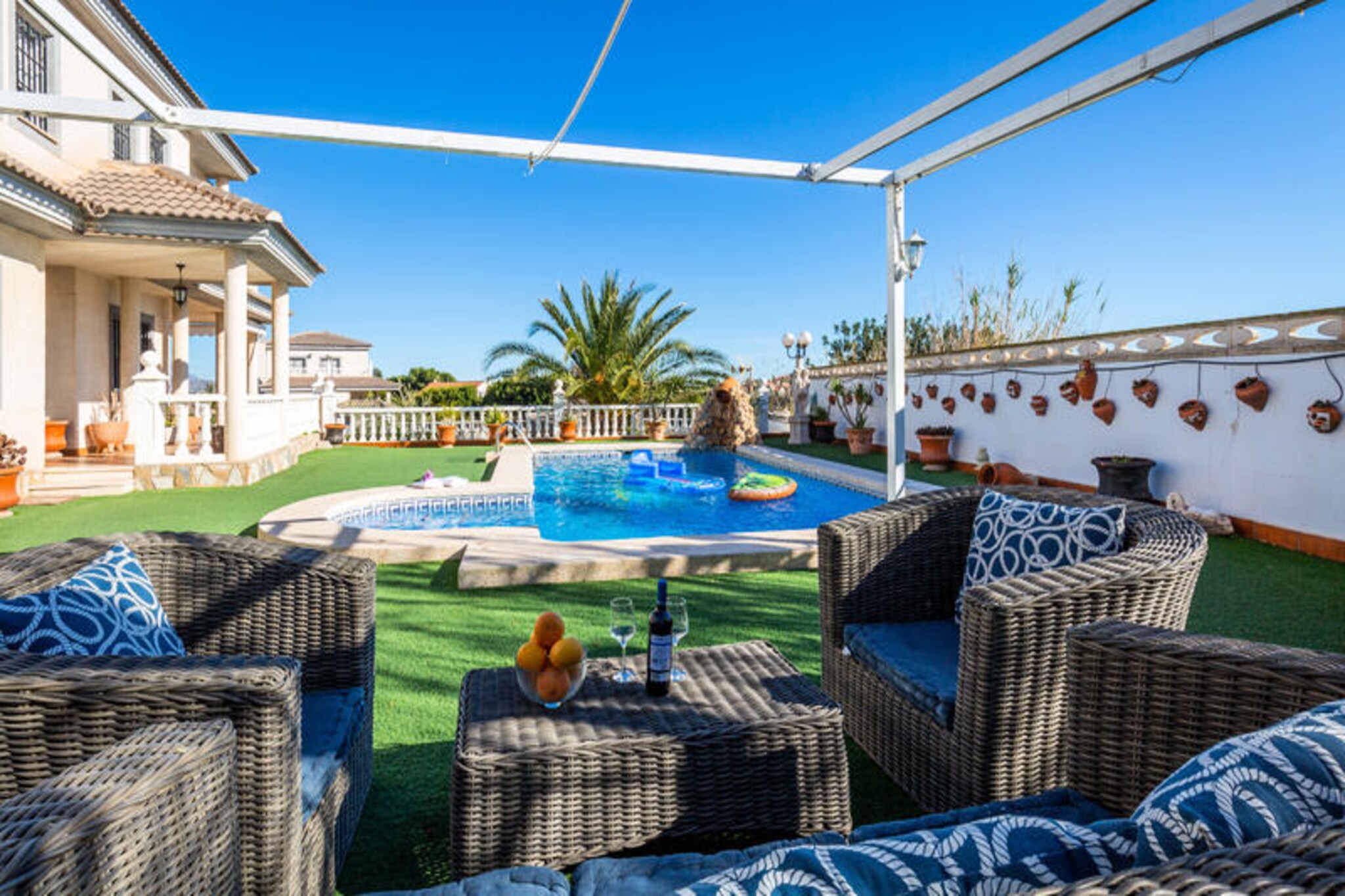 Imagine waking up in a luxurious villa where contemporary Californian design meets the charm of traditional Spanish white villages. This stunning three-story property in Mutxamiel offers an unparalleled retreat for up to 12 guests, just minutes from the golden sands of San Juan and Campello beaches. With six spacious bedrooms, four elegant bathrooms, and a guest toilet near the barbecue area, this villa is the perfect blend of sophistication and comfort, ideal for families or groups of friends seeking a memorable Mediterranean escape.
Step inside and be welcomed by sunlit interiors, where the open-plan living and dining areas flow seamlessly into a fully equipped modern kitchen. Relax in not one, but two inviting living rooms, each adorned with plush furnishings and smart TVs, perfect for unwinding after a day of exploring. The villa’s thoughtful design ensures every guest enjoys privacy and comfort, with premium mattresses, air conditioning, and outdoor access from most bedrooms.
The outdoor spaces are nothing short of spectacular. Lounge by the shimmering private pool, prepare a feast on the barbecue, or dine al fresco under the stars with seating for 12. The upper terrace offers breathtaking mountain views, while the lush vertical gardens on the rear terrace create a serene oasis for your morning coffee or evening wine.
Located just a short drive from Alicante’s vibrant city center, the villa is perfectly positioned to explore the region’s natural and cultural treasures. Visit the Santa Pola Salt Lagoon, enjoy thrilling water rides at Aqualandia, or simply bask in the sun at nearby beaches. With high-speed WiFi, free parking, and pet-friendly amenities, this villa ensures a seamless and unforgettable stay. Your Mediterranean dream vacation starts here.