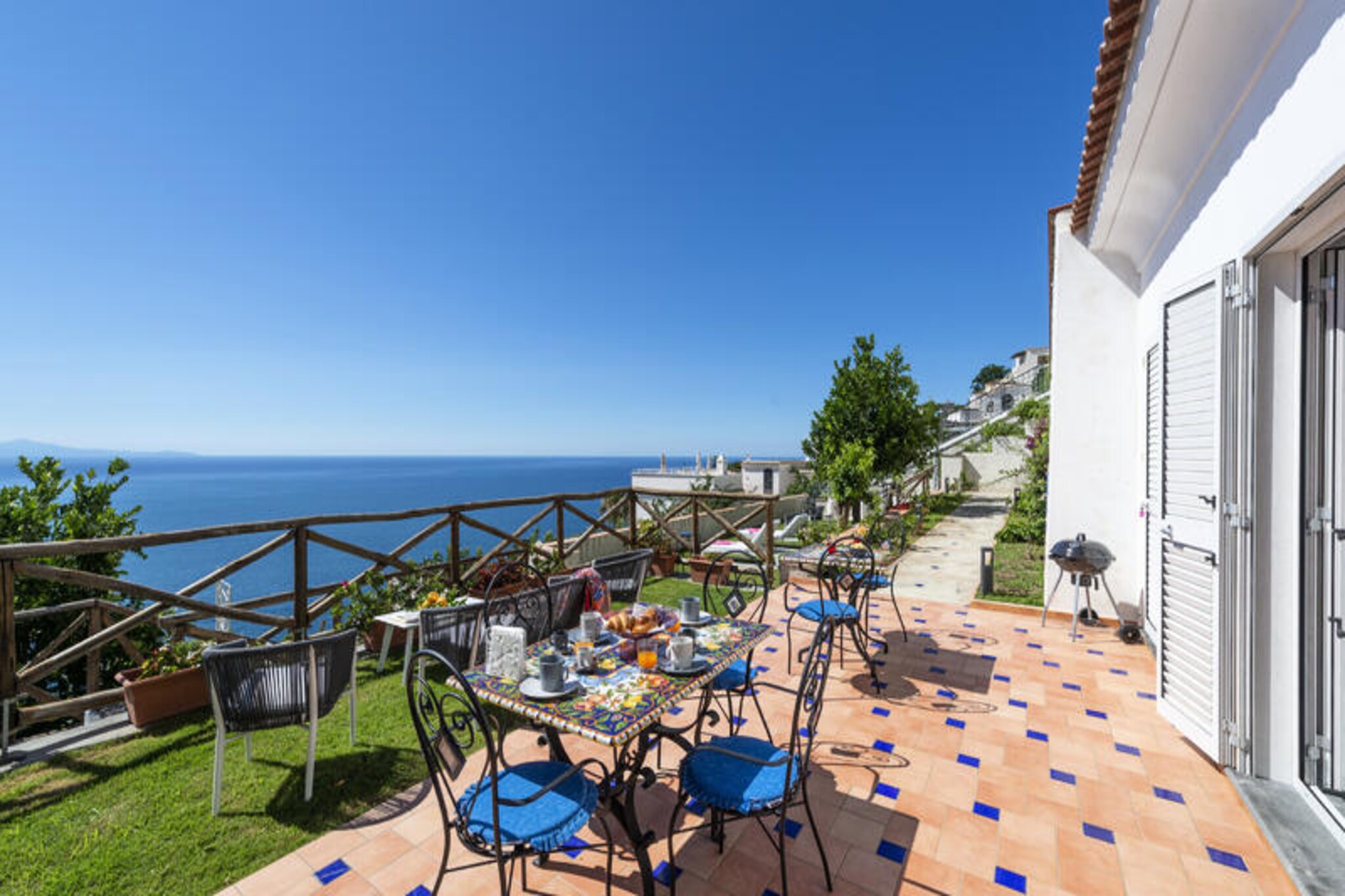 Perched on the eastern side of Praiano, Villa Euriclea offers a serene retreat where Mediterranean charm meets modern comfort. Imagine waking up to the soothing sound of waves and stepping onto a terrace that opens to uninterrupted views of the shimmering sea. This villa, surrounded by lush greenery, is a perfect blend of elegance and simplicity, designed to provide a tranquil escape for up to four guests. Whether you're enjoying a morning coffee on the terrace or unwinding in the garden's solarium, every moment here feels like a celebration of Italy's coastal beauty.  
    Inside, the villa boasts two spacious double bedrooms, each with its own en-suite bathroom, ensuring privacy and comfort. The open-plan living area features a fully equipped induction kitchen and a cozy lounge with a double sofa bed, ideal for relaxing after a day of exploration. The outdoor spaces are a true highlight: a sea-view terrace with a handcrafted Vietri ceramic table for al fresco dining, a barbecue area, and a garden furnished with sun loungers, perfect for soaking up the sun or enjoying a glass of local wine under the stars.  
    Villa Euriclea's location is unbeatable. Just steps away, you'll find the Church of San Luca, local restaurants, a supermarket, and the bus stop, making it easy to explore Praiano and its surroundings. For adventure seekers, the Path of the Gods trail is nearby, offering breathtaking hikes above the Amalfi Coast. The villa is accessible via a short path and steps, adding to its secluded charm. Private parking is available upon reservation, ensuring convenience for those traveling by car.  
    Whether you're seeking relaxation, adventure, or a taste of authentic Italian life, Villa Euriclea promises an unforgettable stay in one of Italy's most picturesque coastal towns.