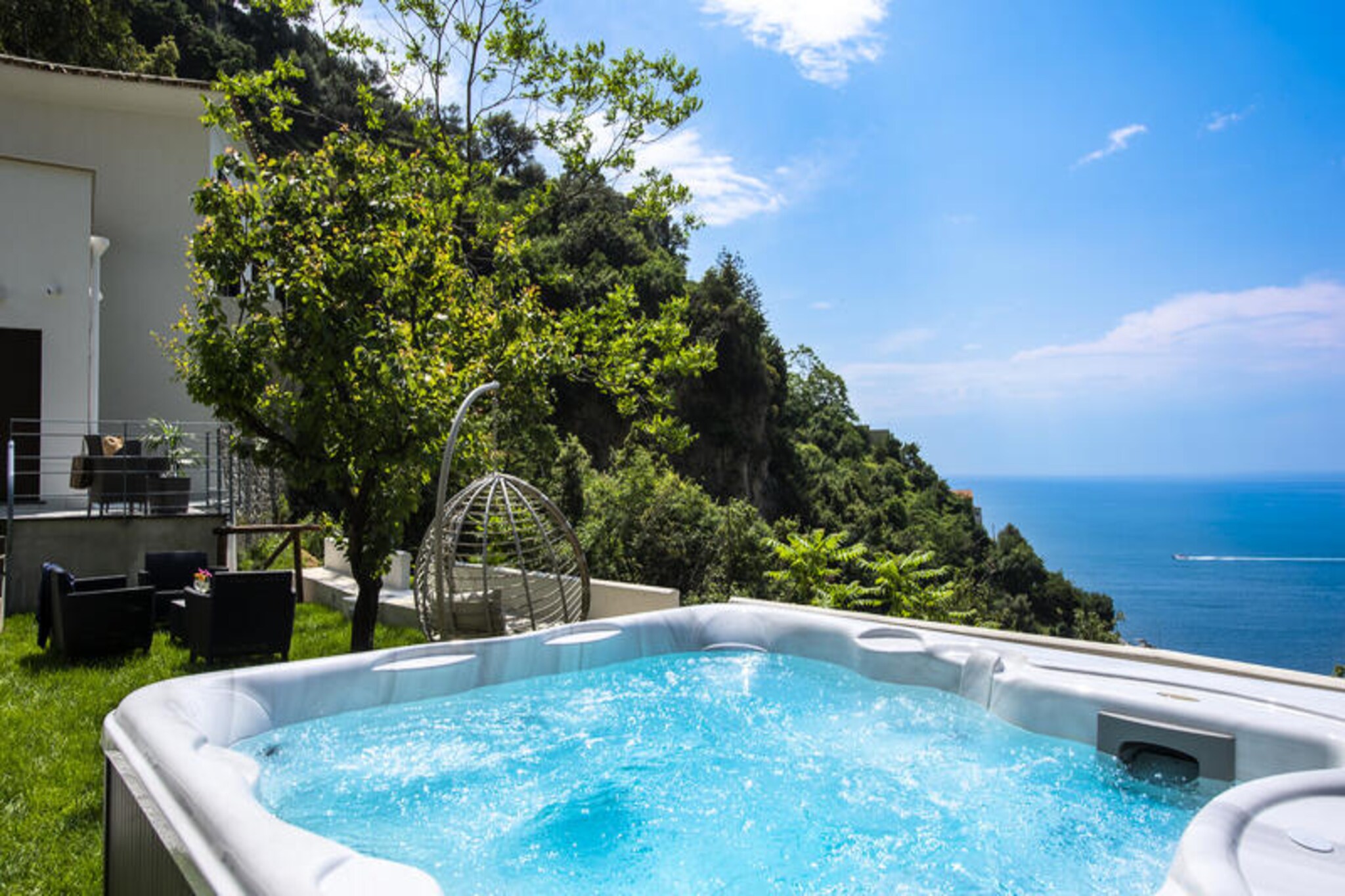 Perched amidst the lush Mediterranean greenery, just 3 km from the iconic Amalfi, Villa Donna Rachele offers a serene retreat with breathtaking sea views. This elegant villa, recently built, combines refined simplicity with luxurious touches, creating an atmosphere of pure relaxation. The outdoor spaces are a true highlight, featuring a heated hydromassage jacuzzi, a barbecue area, and a sea-view garden furnished for unwinding under the Italian sun. Accessible via 90 private steps, the villa ensures privacy and tranquility, with a dedicated parking space conveniently located at the entrance. A car is recommended for exploring the surrounding beauty of the Amalfi Coast.\n\nSpread across two levels, the villa boasts a harmonious blend of indoor and outdoor living. The garden area includes a panoramic terrace perfect for al fresco dining and a jacuzzi for indulgent moments of relaxation. Inside, the Mediterranean-style living room opens to a terrace overlooking the garden, while the open-plan kitchen, equipped with modern amenities, offers stunning sea views through its expansive window. The sleeping arrangements include two double bedrooms with sea-view balconies and a third double bedroom featuring a private terrace and en-suite bathroom with a sensory shower. Two additional bathrooms also feature sensory showers, ensuring a spa-like experience.\n\nVilla Donna Rachele’s prime location makes it easy to explore the Amalfi Coast’s treasures. The SITA bus stop is conveniently located at the villa’s entrance, while a supermarket is just 700 meters away. Amalfi’s historic center, with its charming streets and cultural landmarks, is a short drive away, and the nearby hamlet of Pogerola offers a peaceful escape. Whether you choose to relax in the villa’s luxurious surroundings or venture out to discover the region’s beauty, Villa Donna Rachele promises an unforgettable Italian getaway.
