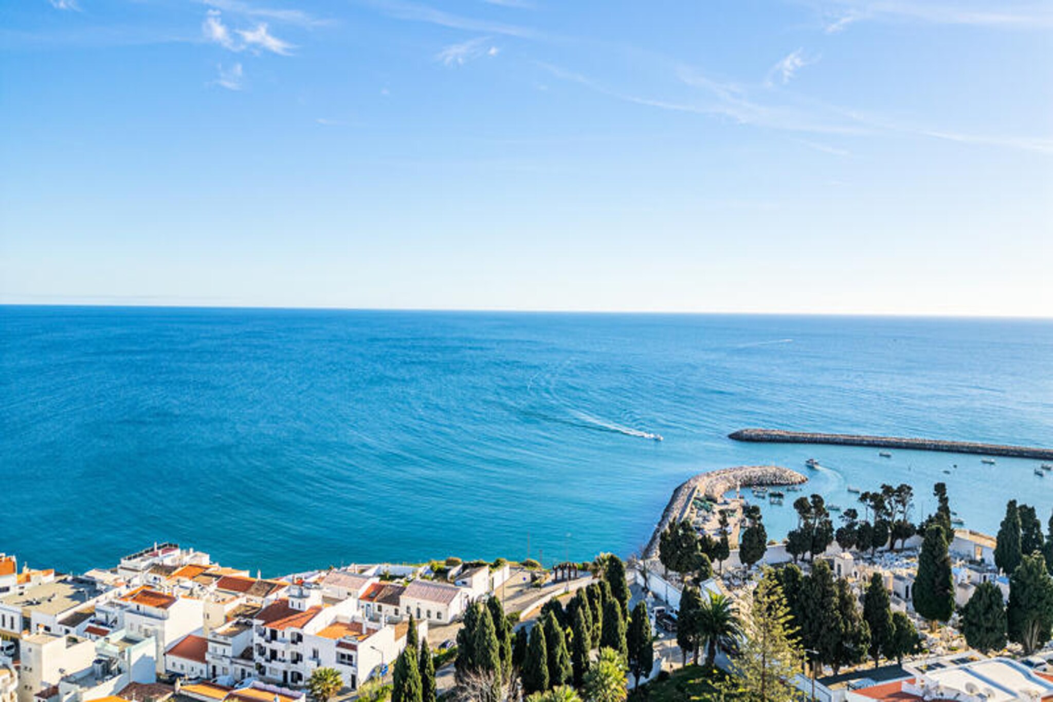 Perched high above the vibrant streets of Albufeira, the Atlantic Apartment offers a serene escape with breathtaking views of the shimmering Atlantic Ocean, the bustling marina, and the town’s iconic whitewashed architecture. This top-floor retreat captures the essence of the Algarve’s charm, blending Mediterranean elegance with the soothing hues of the sea to create a tranquil haven for your holiday. Whether you’re sipping your morning coffee on the balcony or watching the sun dip below the horizon, every moment here is infused with the magic of southern Portugal.
Inside, the one-bedroom apartment is thoughtfully designed to provide both comfort and style. The open-plan living space features a cozy seating area, a fully equipped kitchen, and large windows that flood the room with natural light. The bedroom, adorned with soft linens and calming tones, ensures restful nights after days of exploration. Modern amenities such as WiFi, air conditioning, and a flat-screen TV add to the convenience, making it an ideal choice for couples or solo travelers seeking a peaceful retreat.
Step outside, and you’ll find yourself just a short stroll from Albufeira’s golden beaches, lively restaurants, and charming cobblestone streets. The marina, with its colorful boats and vibrant atmosphere, is perfect for a leisurely afternoon, while nearby attractions like the historic Old Town and the scenic cliffs of São Rafael Beach offer endless opportunities for adventure. For those who love the outdoors, the Algarve’s renowned hiking trails and golf courses are within easy reach.
Whether you’re here to relax by the sea, explore the rich culture of the Algarve, or simply unwind in a picturesque setting, the Atlantic Apartment is your gateway to an unforgettable Portuguese getaway.