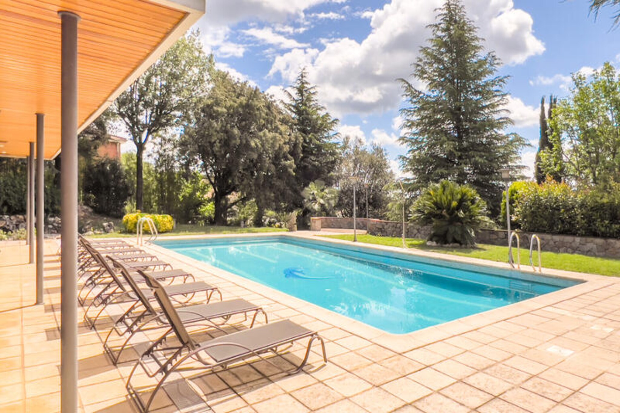 In the heart of Catalonia, where the serene beauty of Lake Banyoles meets the vibrant energy of a sports hub, Sports Villa Banyoles offers an unparalleled retreat for athletes and large groups. This spacious villa, accommodating up to 15 guests, is designed to combine comfort, functionality, and a touch of luxury, making it the perfect base for training, competitions, or simply unwinding in a picturesque setting.
Step inside and discover a thoughtfully designed space featuring seven bedrooms with 14 beds, five bathrooms, and two expansive living and dining areas. The fully equipped kitchen invites you to prepare hearty meals, while the dedicated gym ensures you can maintain your fitness routine. Outside, a magnificent 13 x 7-meter pool awaits, surrounded by lounge chairs and a shaded porch, perfect for relaxing after a day of activities. The outdoor kitchen and barbecue area add a delightful touch for al fresco dining, all within a secure, fenced area for privacy and peace of mind.
Banyoles itself is a paradise for sports enthusiasts. Renowned for its Olympic-sized lake, the town is a haven for rowing, canoeing, and triathlon training. Beyond sports, the natural beauty of the area is breathtaking, with lush forests, rolling hills, and the crystal-clear waters of Lake Banyoles offering endless opportunities for outdoor adventures. Explore cultural gems like the Gothic church of Santa Maria dels Turers or the Monastery of Sant Esteve, and immerse yourself in local traditions at the Banyoles Triathlon or Medieval Fair.
Whether you're here to train, compete, or simply relax, Sports Villa Banyoles provides the perfect balance of tranquility and activity. Book your stay today and experience the ultimate retreat in one of Catalonia's most captivating destinations.