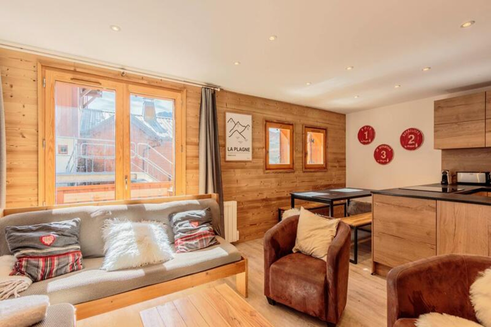 High in the serene alpine village of Plagne Soleil, this charming chalet invites you to experience the perfect mountain retreat. Bathed in sunlight and surrounded by breathtaking peaks, it offers a tranquil escape where the beauty of the French Alps meets the comforts of modern living. Whether you're here to carve fresh tracks on the slopes or explore scenic hiking trails, this chalet provides the ideal base for your adventures.
Spanning 80m² across two levels, the chalet comfortably accommodates up to eight guests. The first level features a spacious and inviting living room complete with a cozy fireplace, a sunny balcony, and a large dining area perfect for family gatherings. The open-plan kitchen is fully equipped with everything from a Nespresso coffee maker to a fondue set, ensuring you can enjoy hearty alpine meals with ease. A private bedroom with an en-suite shower room and toilet is also located on this floor. Upstairs, you'll find three additional bedrooms, each with its own shower room and toilet, offering flexible sleeping arrangements with single beds that can be joined or separated. Additional amenities include a ski locker and a shoe dryer for your convenience.
Plagne Soleil's prime location in the heart of the ski area ensures easy access to the slopes and hiking paths. A free shuttle service connects you to nearby Plagne Village, adding to the convenience. After a day of adventure, unwind on the balcony, soaking in the panoramic views and crisp mountain air. With its blend of comfort, charm, and unbeatable location, this chalet promises an unforgettable alpine getaway.