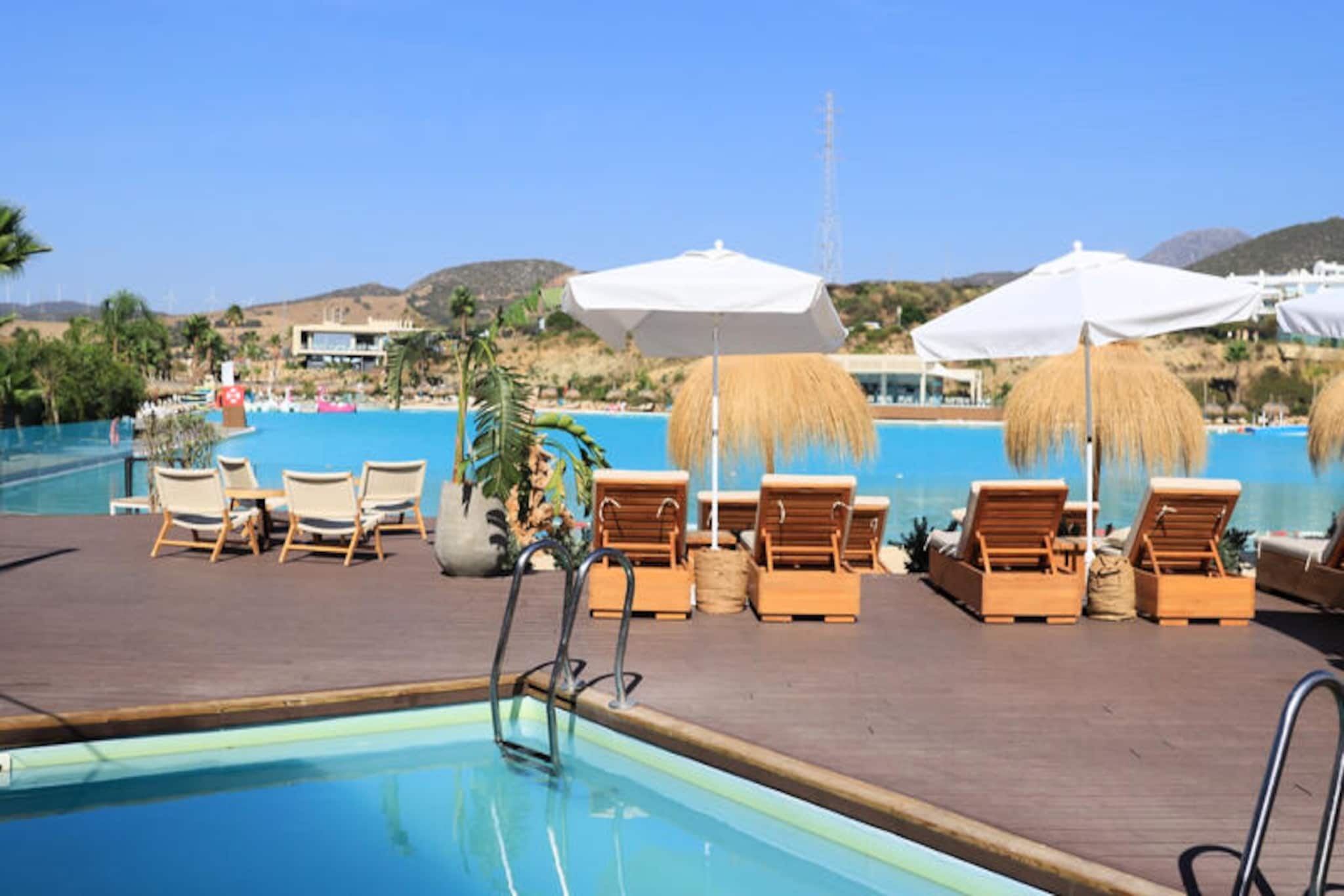 Imagine waking up to the gentle sound of palm trees swaying in the breeze, with the sparkling waters of Europe’s first Crystal Lagoon just steps away. Nestled in the serene Casares/Estepona region on the Costa del Sol, this luxurious apartment offers an unparalleled blend of modern comfort and Mediterranean charm. Surrounded by 40,000 m² of lush tropical gardens, the property invites you to experience a tranquil retreat while enjoying exclusive access to the lagoon’s sandy beach and crystal-clear waters. Whether you’re here to relax or explore, this destination promises unforgettable moments under the Andalusian sun. \n\nDesigned for up to four guests, the apartment features two spacious bedrooms, a private terrace with outdoor furniture, and a garden perfect for soaking up the sunshine. The fully equipped kitchen includes everything you need to prepare delicious meals, from a Nespresso coffee machine to a dishwasher. Modern amenities such as high-speed Wi-Fi, air conditioning, and a Smart TV with international channels ensure a comfortable stay for families or couples. Guests also have access to shared facilities, including a swimming pool, children’s play area, and outdoor parking. \n\nLocated just 100 meters from the lagoon, you’ll find on-site dining at the Alcazaba Lagoon Restaurant, offering Mediterranean cuisine in a relaxed setting. Estepona’s sandy beaches and vibrant town center are just a short drive away, where you can explore local boutiques, traditional restaurants, and the historic old town. Golf enthusiasts will appreciate the proximity to Estepona Golf and other prestigious courses like Valderrama and Los Flamingos, all within easy reach. \n\nWhether you’re seeking adventure in the Sierra Crestellina Natural Park, indulging in water sports at the lagoon, or simply unwinding in the sun, this property is your gateway to the best of the Costa del Sol. Book your stay today and discover the perfect balance of luxury, nature, and relaxation.