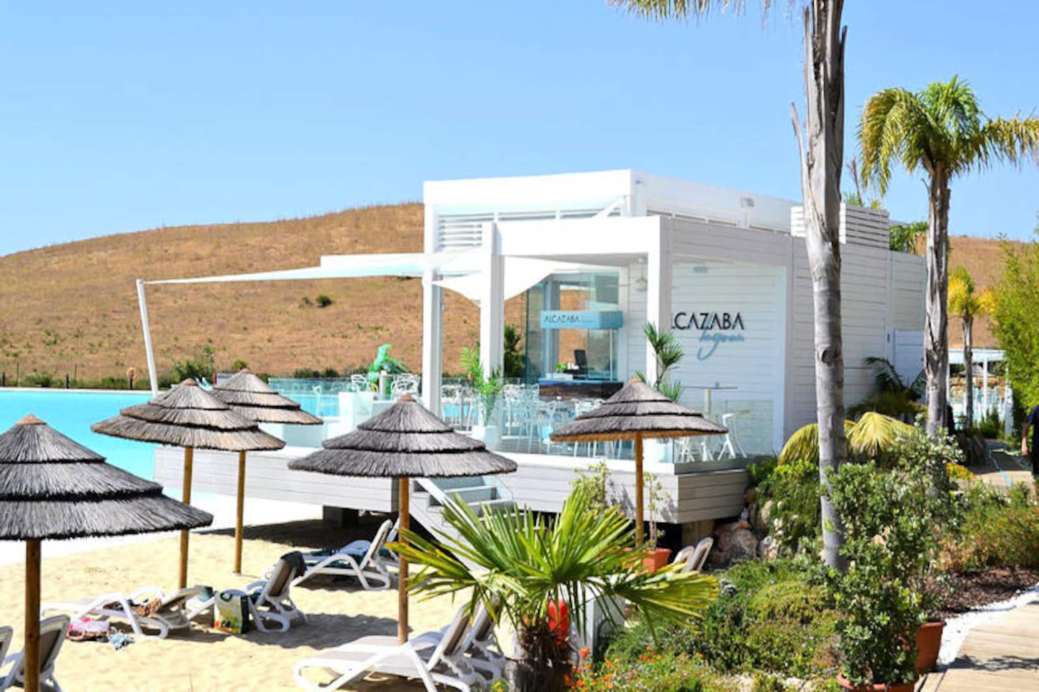 Imagine waking up to the tranquil beauty of Europe’s first Crystal Lagoon, a shimmering oasis exclusively for guests of the ALCAZABA Lagoon resort. Nestled in the picturesque Casares/Estepona area of the Costa del Sol, this Mediterranean-style retreat offers a perfect blend of modern luxury and natural charm. Surrounded by lush, exotic gardens spanning over 40,000 m², the resort’s whitewashed architecture with soft contours creates an inviting atmosphere that complements the sunny Andalusian landscape. Whether you’re seeking relaxation or adventure, this destination promises unforgettable moments. \n\nThe apartment, designed for two guests, is a haven of comfort and convenience. Featuring one bedroom, a fully equipped kitchen, and a private terrace, it’s ideal for couples or solo travelers. Amenities include air conditioning, high-speed WiFi, a SMART TV with multilingual channels, and access to shared pools, including a children’s pool. Guests can also enjoy free lagoon access, sunbed chairs, gym facilities, and beach towels. For families, the resort offers a children’s area and pool guards, ensuring peace of mind for parents. \n\nJust steps away, the lagoon’s sandy beach invites you to unwind or try water activities like kayaking and paddleboarding. Golf enthusiasts will find paradise with Estepona Golf only 1 km away and several world-class courses within a short drive, including the renowned Valderrama Golf Club. The vibrant town of Estepona, with its charming old town and sandy beaches, is only 4 km away, offering authentic Spanish dining and cultural experiences. \n\nWhether you’re exploring the nearby Sierra Crestellina on a hike, savoring Andalusian cuisine at the lagoon’s beach restaurant, or simply soaking in the serene surroundings, ALCAZABA Lagoon is your gateway to the ultimate Costa del Sol escape.