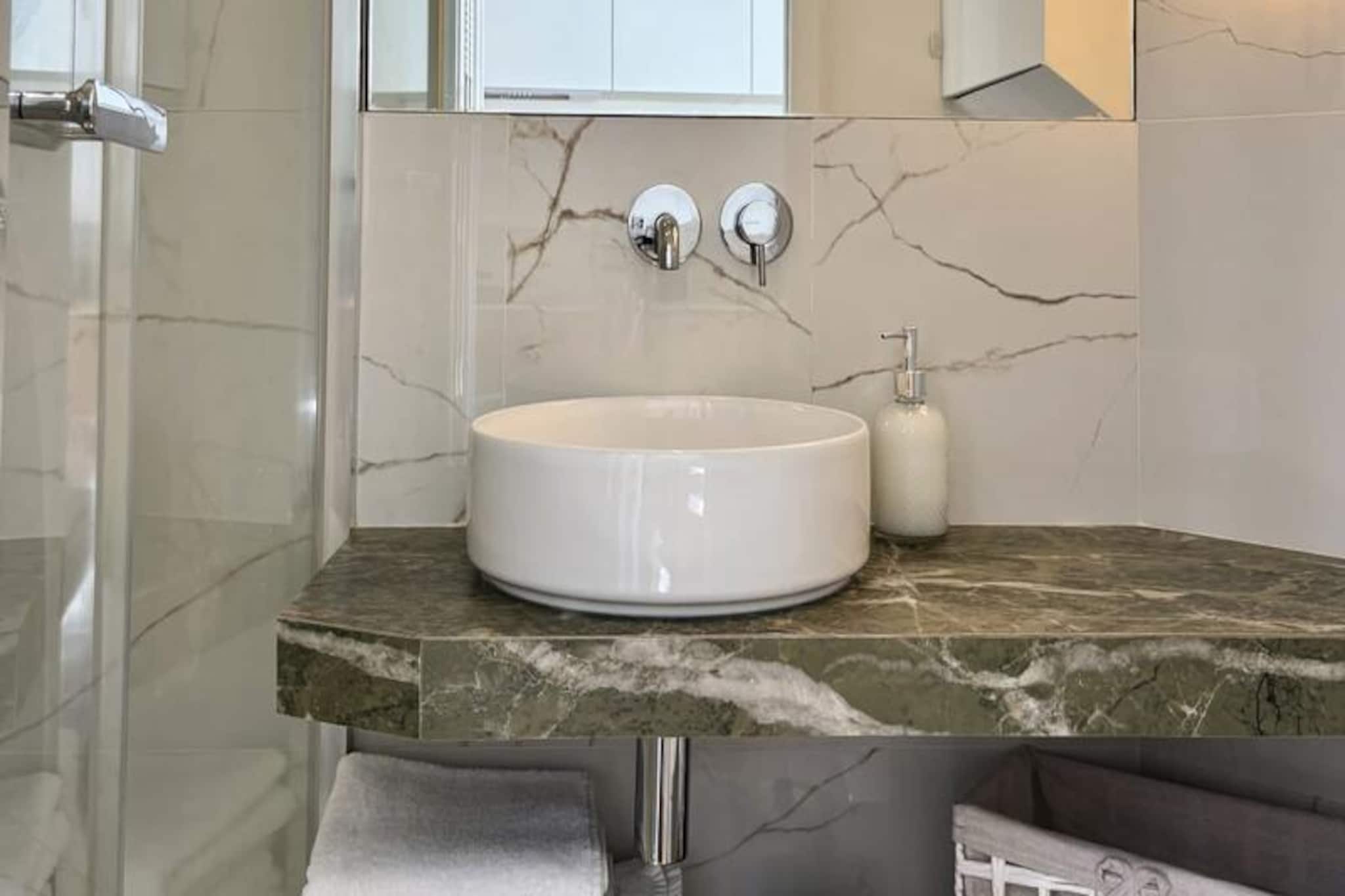 Step into a haven of tranquility and modern elegance in the heart of Courbevoie, where this beautifully renovated apartment offers a perfect blend of style and comfort. Just a short walk from the T2 tram station, you’ll find yourself seamlessly connected to La Défense in 4 minutes and central Paris in no time, making this an ideal base for both business and leisure travelers. The quiet residential neighborhood of Les Fauvelles provides a peaceful retreat while keeping you close to the vibrant city life. \n\nThis thoughtfully designed apartment has been crafted with meticulous attention to detail, offering a chic and contemporary ambiance. From the high-end bedding ensuring restful nights to the glass partition that floods the space with natural light, every feature has been curated for your comfort. The living area invites you to unwind on a plush sofa, enjoy your favorite shows on a 50\