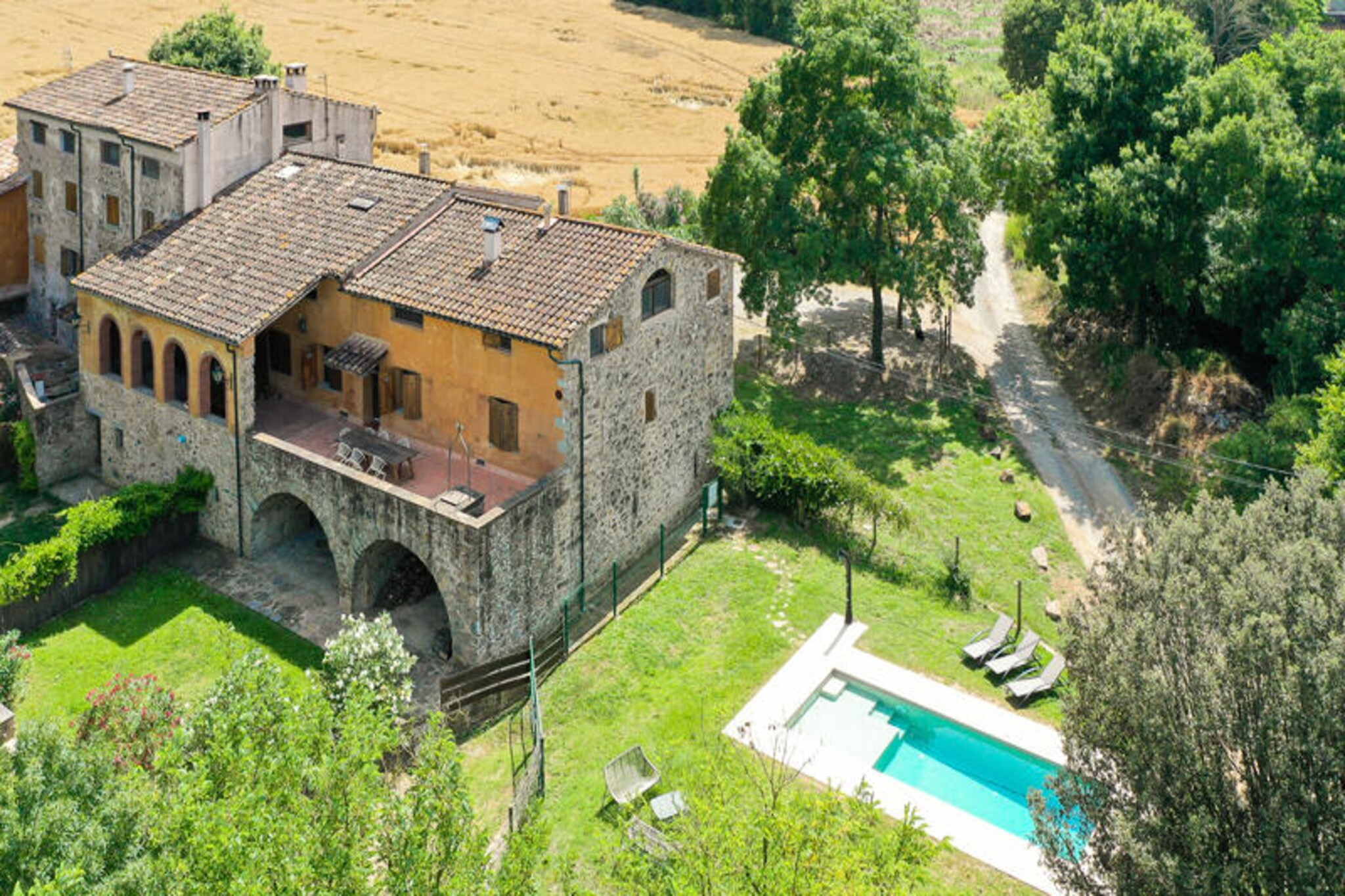 In the serene valley of Els Angles, surrounded by the breathtaking landscapes of La Garrotxa, Can Blanc de Montagut Dalt offers an authentic Catalan countryside experience. This charming apartment, part of a beautifully restored farmhouse, is the perfect retreat for families and groups seeking adventure and tranquility in equal measure. With its rustic charm and modern comforts, it invites you to immerse yourself in the natural beauty of the region.
The apartment comfortably accommodates up to five guests with two spacious bedrooms featuring extra-large beds and ample storage. The living area, with its cozy wood-burning stove, is an inviting space to unwind after a day of exploring. A large window floods the room with natural light and offers stunning views of the surrounding fields and mountains. The fully equipped kitchen, complete with modern appliances, ensures you have everything needed to prepare delicious meals. A modern bathroom with an open shower and baby changing facilities adds to the convenience.
Step outside to discover a shared garden, swimming pool, and barbecue area, perfect for relaxing or socializing with other guests. The property’s location is a gateway to La Garrotxa’s wonders. Explore the volcanic landscapes, hike along the Fluvià River, or visit the medieval village of Castellfollit de la Roca perched on a dramatic basalt cliff. Within a short drive, you’ll find picturesque towns like Besalú and Santa Pau, the Croscat and Santa Margarida volcanoes, and the enchanting Fageda d'en Jordà beech forest.
Whether you’re hiking, cycling, or simply soaking in the serene surroundings, Can Blanc de Montagut Dalt offers an unforgettable escape into the heart of Catalonia’s natural and cultural treasures.