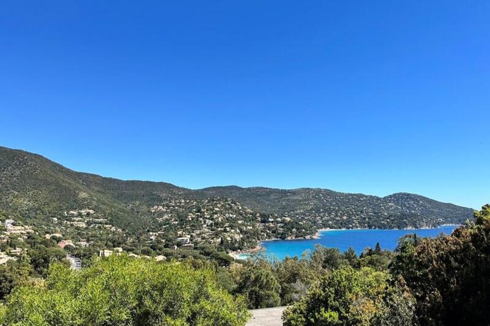 Imagine waking up to the gentle sound of waves and the scent of pine trees in the air. Villa Tanit, perched on the serene Cap Nègre in Pramousquier, offers a tranquil escape with breathtaking views of the Mediterranean. Just a short stroll from the secluded Pramousquier Beach, known as 'The Mysterious Beach,' this villa is a haven for those seeking relaxation and natural beauty. With its lush gardens, sun-drenched terraces, and a private swimming pool, every corner of this home invites you to unwind and savor the charm of the Côte d'Azur.
The villa’s interior is as impressive as its surroundings. Spread across three levels, it features five bedrooms, each thoughtfully designed for comfort and privacy. The main living area boasts floor-to-ceiling bay windows that open onto a terrace with panoramic sea views. Modern amenities include a fully equipped kitchen, air conditioning, Wi-Fi, and even a paddleboard for your seaside adventures. Whether you’re enjoying a meal in the spacious dining area, lounging by the pool, or relaxing in the jacuzzi, every moment here feels like a retreat.
Beyond the villa, the secure cycle path leads you to the 12 beaches of Le Lavandou, perfect for exploring the coastline. Pramousquier Beach, with its hidden paths and inviting beachside restaurants, is just a 5-minute walk away. For those who love water sports, pedal boats are available for rent, adding a touch of adventure to your stay.
Whether you're traveling with family, friends, or your partner, Villa Tanit offers an unforgettable blend of comfort, elegance, and the timeless allure of the French Riviera. Let the Mediterranean breeze and golden sunsets create memories that will last a lifetime.