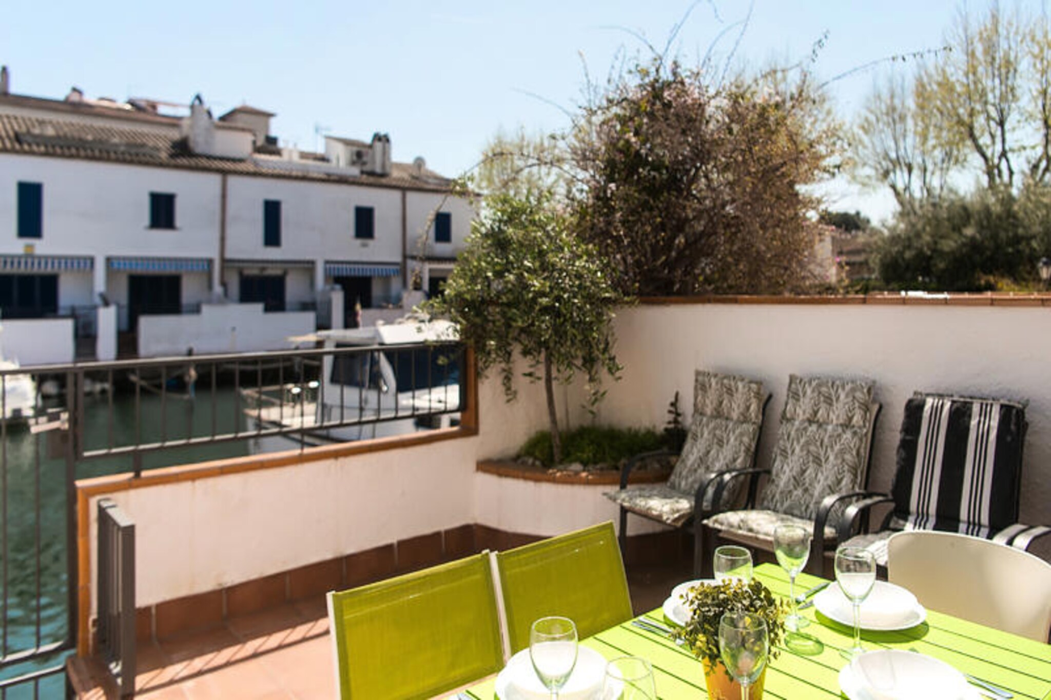 Step into a tranquil retreat in the heart of Empuriabrava, where the gentle ripples of the canal set the tone for a serene getaway. This charming two-story house spans 100 m² and offers a perfect blend of comfort and picturesque views, making it an idyllic choice for families or groups of up to six guests. Whether you're sipping coffee on the terrace or unwinding in the cozy living room, every corner of this home invites relaxation and connection with the beauty of its surroundings. \n\nInside, the house boasts a spacious living area with plush seating and a dining space perfect for sharing meals and stories. The fully equipped kitchen is a haven for culinary enthusiasts, featuring modern appliances and all the essentials for preparing delicious dishes. Upstairs, three inviting bedrooms await: two with twin beds and one with a comfortable double bed. Two bathrooms—one with a sleek shower and the other with a luxurious bathtub—offer a refreshing oasis after a day of exploration. The soothing green and turquoise tones of the bathrooms add a touch of harmony to your stay. \n\nThe terrace is the true gem of this property, offering direct views of the canal and access to a private jetty. Start your mornings with the tranquil sound of water or end your day watching the sun dip below the horizon. For those who love water sports or leisurely strolls, this location is a dream come true. Nearby, you'll find a variety of cafés and restaurants serving local and international delights, ensuring your culinary cravings are always satisfied. \n\nEmpuriabrava is a unique destination where the charm of the canals meets the vibrancy of Mediterranean life. Whether you're here for relaxation or adventure, this house provides the perfect base for creating unforgettable memories. Let the beauty of the water and the comfort of this home be the backdrop to your dream vacation.