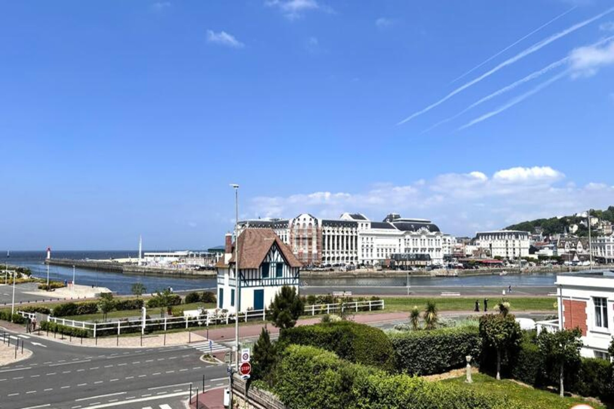 Where the charm of Normandy meets the elegance of Deauville, La Villa Mirabeau invites you to experience a truly unforgettable stay. Overlooking the sea and the picturesque port entrance of Deauville-Trouville-sur-Mer, this stunning manor house blends traditional Norman architecture with contemporary luxury. From its sunlit balconies to its secluded solarium, every corner of this home is designed to enchant and inspire. Whether you're sipping coffee as the morning light dances on the waves or unwinding in the cozy courtyard, La Villa Mirabeau offers a serene escape just steps from Deauville's vibrant heart. 
 
 Spanning three levels, this characterful villa comfortably accommodates up to 8 guests. The ground floor boasts a spacious living room with a monumental fireplace, perfect for cozy evenings, and an open-plan kitchen equipped with high-end appliances like a SMEG refrigerator and Nespresso machine. Upstairs, you'll find a relaxation area with a sofa bed and TV, a master suite with breathtaking port views, and a smaller bedroom with its own shower. The top floor is a haven of luxury, featuring another master suite with panoramic views, a private bathroom with a walk-in shower and bathtub, and access to a secluded solarium for ultimate relaxation. Every room, except one, offers a private balcony to soak in the coastal beauty.
 
 Located in the heart of Deauville, the villa is just a 3-minute stroll to the beach and its iconic boardwalk, a 5-minute walk to the lively town center, and under 10 minutes to the train station. Nearby, explore the bustling fish market, the Barrière Casinos, and a variety of renowned restaurants and art galleries. For those seeking both tranquility and excitement, this location is unparalleled.
 
 Whether you're here to indulge in Deauville's chic lifestyle, explore the scenic Normandy coast, or simply relax in a home that feels like a private retreat, La Villa Mirabeau promises a stay filled with elegance, comfort, and unforgettable memories.