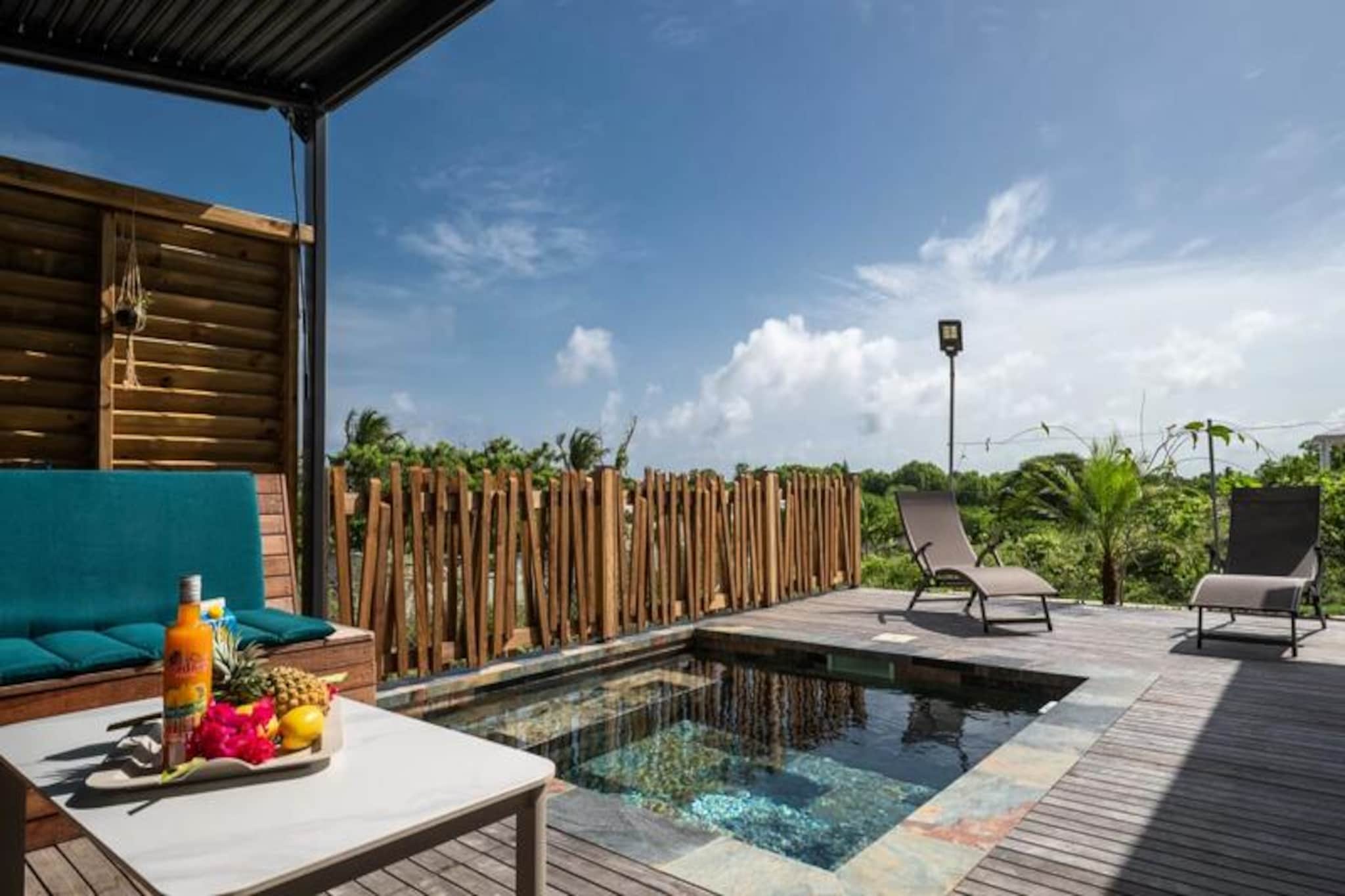 Step into a serene tropical retreat at Villa Karaval, a charming haven in the sought-after Cayenne district of Saint-François. This single-story villa, designed for up to four guests, combines Caribbean allure with modern comforts, creating the perfect setting for a rejuvenating getaway. From the moment you arrive, the tranquil ambiance of the bioclimatic gazebo and the lush surroundings will invite you to unwind and embrace the island lifestyle. The villa's private plunge pool, framed by a stunning Ipe wood deck, offers a refreshing escape under the tropical sun. \n\nInside, the villa boasts a fully equipped kitchen, ideal for preparing delicious meals with local ingredients. From a traditional oven to a charcoal barbecue, every detail has been considered to enhance your culinary experience. The two air-conditioned bedrooms, each featuring a cozy 140cm bed, promise restful nights after days of exploration. A modern bathroom with provided toiletries adds to the convenience, ensuring a seamless stay. \n\nVilla Karaval’s location is unbeatable. Just minutes from the vibrant center of Saint-François, you’ll find supermarkets, bakeries, and shops at your fingertips. The nearby beaches and cultural attractions offer endless opportunities for adventure, from lounging on pristine sands to immersing yourself in the local heritage. For added ease, Cayenne International Airport is just a short drive away, making your arrival and departure effortless. \n\nWhether you’re seeking relaxation by the pool, culinary delights, or the thrill of discovering Guadeloupe’s treasures, Villa Karaval is your gateway to an unforgettable Caribbean escape. Let the gentle breezes and warm hospitality of Saint-François make your stay truly special.