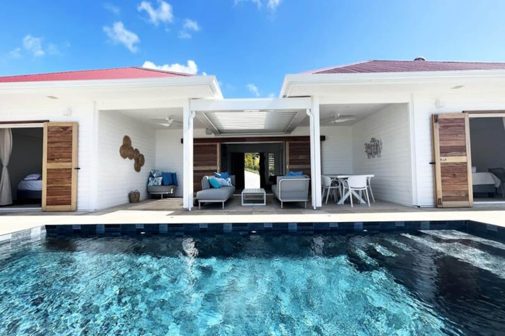 On the serene heights of Grand-Bourg, Villa Olina offers an idyllic escape where tranquility meets luxury. Surrounded by the lush beauty of Marie-Galante, this villa is a sanctuary for those seeking relaxation and connection with nature. Imagine waking up to panoramic views of the island's verdant landscapes, with the gentle Caribbean breeze inviting you to step outside and embrace the day. This is more than a vacation home; it’s your private retreat under the Guadeloupe sun.
With three elegantly designed bedrooms, each featuring a double bed and private bathroom, Villa Olina ensures maximum comfort and privacy for up to six guests. The spacious and light-filled living room creates a welcoming atmosphere, while the modern, fully equipped kitchen opens onto a large terrace, perfect for shared meals and moments of togetherness. Outside, a sparkling swimming pool awaits, offering the perfect spot to unwind and soak up the sun. Every detail, from the air conditioning in all rooms to the high-quality linens, has been thoughtfully curated to provide a seamless and luxurious experience.
Located just five minutes from the charming town center of Grand-Bourg, the villa is ideally positioned to explore the island’s treasures. Stroll through local markets, savor Creole delicacies at nearby restaurants, or visit the pristine beaches of La Feuillère and Anse Canot, perfect for swimming and sunbathing. Nature enthusiasts will delight in the hiking trails and sugarcane fields that define Marie-Galante’s unique charm.
Whether you’re seeking adventure or serenity, Villa Olina offers the perfect balance. With exclusive concierge services, including excursions, car rentals, and airport transfers, every aspect of your stay is tailored to your needs. Let Villa Olina be your gateway to an unforgettable Caribbean experience.