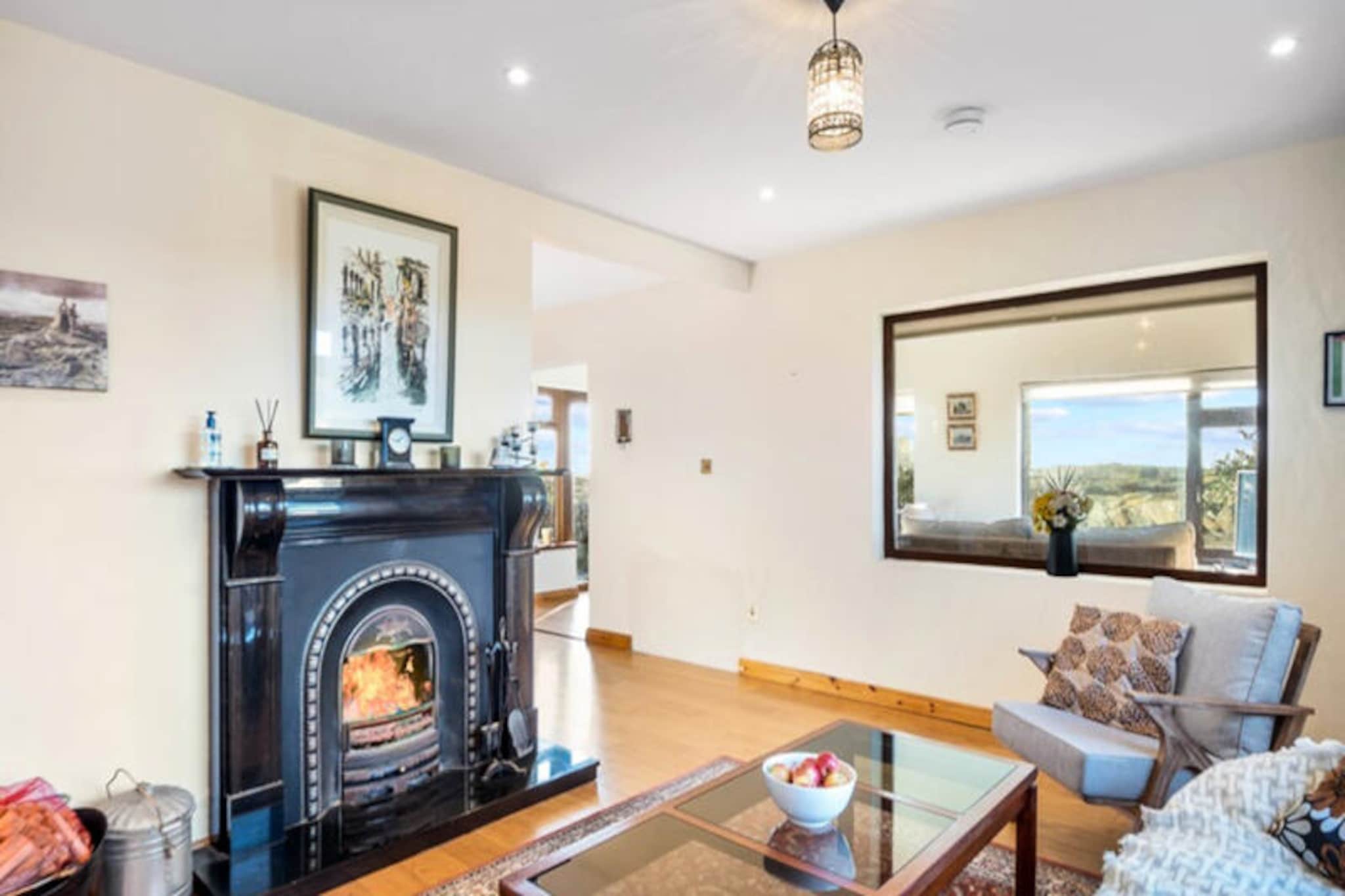 Surrounded by the rugged beauty of Ireland's west coast, this charming home in Ballyconneely offers a tranquil escape for those seeking a blend of comfort and natural splendor. With its idyllic location near Truska Lough and just a short drive from the pristine beaches of Doonloughin and Aillebrack, this property invites you to immerse yourself in the unspoiled landscapes of Connemara. Whether you're gazing out at the rolling hills or enjoying the fresh Atlantic breeze, every moment here feels like a breath of fresh air. \n\nInside, the house is thoughtfully designed to accommodate up to six guests across three cozy bedrooms. The spacious 153 m² layout includes a warm living area with a fireplace, perfect for unwinding after a day of exploring. The American-style kitchen is fully equipped with modern appliances, including a dishwasher and microwave, making meal preparation a breeze. Additional amenities such as Wi-Fi, a washing machine, tumble dryer, and on-site parking ensure a comfortable and convenient stay. Step outside to the private garden, complete with outdoor furniture and a barbecue, where you can savor al fresco dining amidst the serene surroundings. \n\nThe location is a gateway to Connemara's many treasures. Just 5 km away, the renowned Connemara Golf Links offers a world-class golfing experience with breathtaking views. Nearby, the charming village of Ballyconneely provides essential amenities, including a supermarket, cafes, and traditional Irish pubs. For a day trip, the vibrant town of Clifden, just 14 km away, boasts a variety of restaurants, shops, and cultural attractions. Nature enthusiasts will relish the proximity to Connemara National Park, while the stunning Coral Strand Beach and Mannin Bay are perfect for seaside adventures. \n\nWhether you're seeking outdoor pursuits, a peaceful retreat, or a taste of authentic Irish hospitality, this Ballyconneely home is the ideal base for creating unforgettable memories in the heart of Connemara.