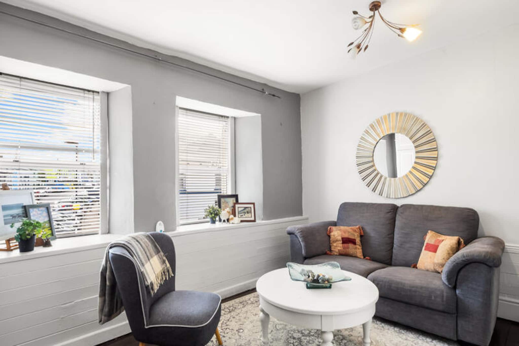 On the rugged shores of Ireland’s Wild Atlantic Way, this charming apartment in Clifden offers an intimate retreat for two. With its cozy ambiance and breathtaking surroundings, it’s the perfect base to explore the unspoiled beauty of Connemara. Imagine waking up to the crisp ocean breeze and enjoying a morning coffee on your private balcony, where the views are as inspiring as the landscapes that await your adventures. Whether you’re seeking tranquility or outdoor exploration, this property invites you to embrace the magic of Ireland’s west coast. \n\nInside, the apartment spans 100 m² of thoughtfully designed space, blending comfort and practicality. The open-plan kitchen is fully equipped with modern appliances, including an electric hob, oven, microwave, and refrigerator, ensuring you can prepare meals with ease. The living area, complete with a fireplace and TV, offers a warm and inviting space to unwind after a day of discovery. Additional amenities such as Wi-Fi, electric heating, a washing machine, and a hairdryer ensure a hassle-free stay. The bedroom, designed for restful nights, complements the overall sense of coziness and charm. \n\nClifden, often referred to as the capital of Connemara, is a vibrant town brimming with character. From traditional pubs and artisan shops to scenic drives along the Sky Road, there’s no shortage of activities to enrich your stay. Nearby, you’ll find pristine beaches, rugged hiking trails, and cultural landmarks that showcase Ireland’s rich heritage. Whether you’re exploring Kylemore Abbey or taking in the panoramic views at Derrigimlagh Bog, every moment is an opportunity to connect with nature and history. \n\nThis apartment is more than just a place to stay; it’s a gateway to unforgettable experiences. Let the charm of Clifden and the allure of Connemara create memories that will linger long after your journey ends.