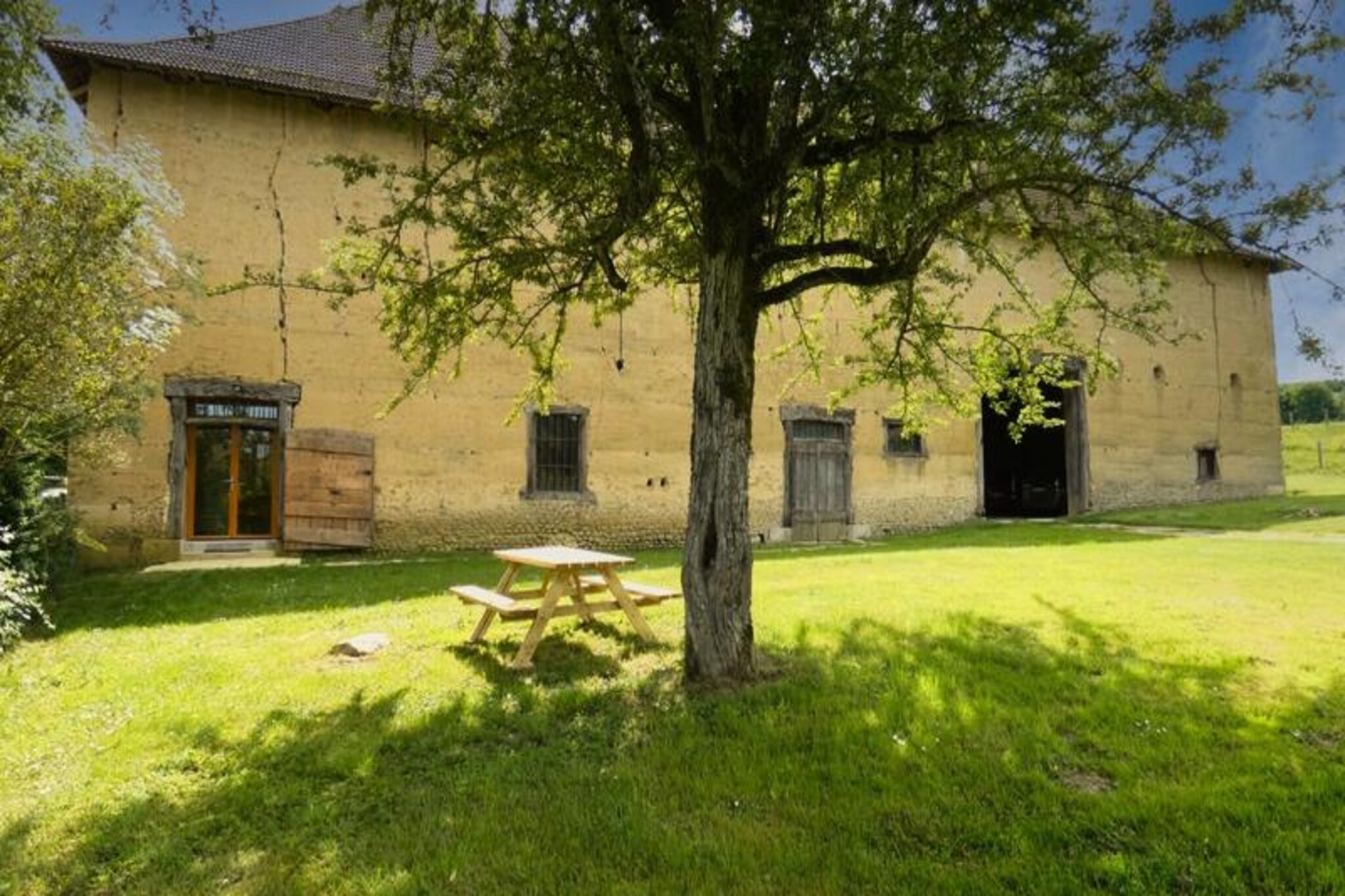 In the serene hills above Paladru, where nature whispers and time slows, La Bergerie offers a tranquil retreat for those seeking peace and authenticity. Surrounded by lush greenery and just a 3-minute drive from the charming village of Paladru, this beautifully renovated former sheepfold invites you to unwind and reconnect with the simple joys of life. Perfect for nature enthusiasts, history buffs, and anyone yearning for a rejuvenating escape, this cottage is a true gem in the French countryside. 
 
 This 60 m² studio cottage, set within a traditional rammed-earth farmhouse, has been lovingly restored to preserve its rustic charm. Original features like the old manger, now repurposed as storage, and exposed beams visible through quaint windows, create a warm and inviting atmosphere. The spacious and bright living area features two large bay windows that open onto a verdant landscape, filling the space with natural light. Three comfortable sofas, two of which double as sofa beds, ensure a cozy stay, while the well-equipped kitchen and modern bathroom provide all the conveniences you need. Outside, a private garden with a picnic area, barbecue, and aromatic herbs awaits, offering the perfect spot to relax amidst the peaceful surroundings. 
 
 Within minutes, you’ll find the sparkling waters of Lake Paladru, perfect for sailing, diving, or simply enjoying the beaches. Hiking and biking trails start right from your doorstep, while the nearby Archaeological Museum and local markets in Charavines add cultural and culinary delights to your stay. For a touch of adventure, explore treetop parks, the Walibi amusement park, or the famous Chartreuse cellars in Voiron, all within a short drive. 
 
 Whether you’re here to explore, relax, or immerse yourself in the beauty of the French countryside, La Bergerie promises an unforgettable experience. Let the charm of this historic retreat and its idyllic surroundings create memories you’ll cherish forever.