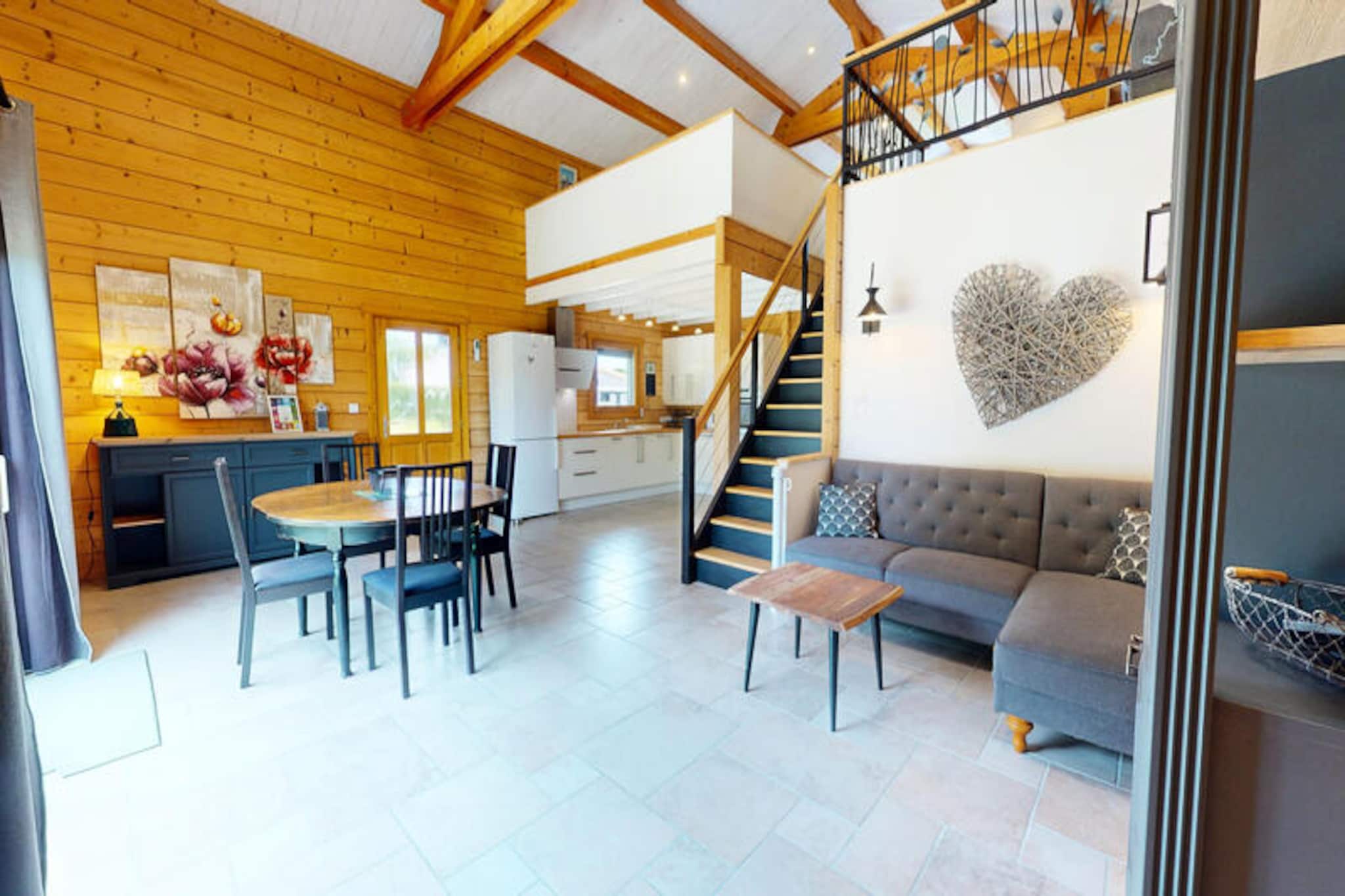 In the serene town of Saint-Maixent-sur-Vie, where countryside charm meets ocean breezes, this enchanting wooden chalet offers a unique escape in the Vendée region. A mere 10 minutes from the golden beaches of Saint-Gilles-Croix-de-Vie, this holiday home invites you to unwind in a tranquil setting surrounded by nature. Imagine mornings filled with birdsong, afternoons exploring the nearby coastline, and evenings spent under the stars in the privacy of your own wooded garden. Here, simplicity and warmth create the perfect atmosphere for family or friends to reconnect and recharge. \n\nStep inside to discover a spacious living room with cathedral-style ceilings, exuding a cozy ambiance with its wood-paneled walls. The open-plan kitchen is fully equipped with modern appliances, including a refrigerator, dishwasher, and oven, ensuring effortless meal preparation. The ground floor features two inviting bedrooms—a double and two single beds—alongside a shower room. Upstairs, the large mezzanine boasts another double bed and an open-plan bathroom, offering a peaceful retreat. With televisions in every room and a Hi-Fi system, comfort and entertainment are at your fingertips. \n\nOutside, the 600 m² private garden is a haven for relaxation and fun. A covered terrace with garden furniture, a barbecue for summer grilling, and a children’s play area make it ideal for outdoor gatherings. Whether you’re savoring a meal al fresco or watching the little ones play, the garden is a space to create lasting memories. \n\nThe location is unbeatable: just minutes from Saint-Gilles-Croix-de-Vie’s vibrant fishing port and sandy beaches, 20 minutes from Bretignolles-sur-Mer’s surfing hotspots, and 25 minutes from Saint-Jean-de-Monts. Explore local markets brimming with fresh seafood, cheeses, and Vendée wines, or embark on scenic bike rides along the Vie River. With leisure parks, water sports, and family-friendly activities nearby, every day offers something new to discover. \n\nReconnect with nature, embrace the coastal lifestyle, and experience the charm of this wooden chalet—a true gem in the heart of the Vendée.