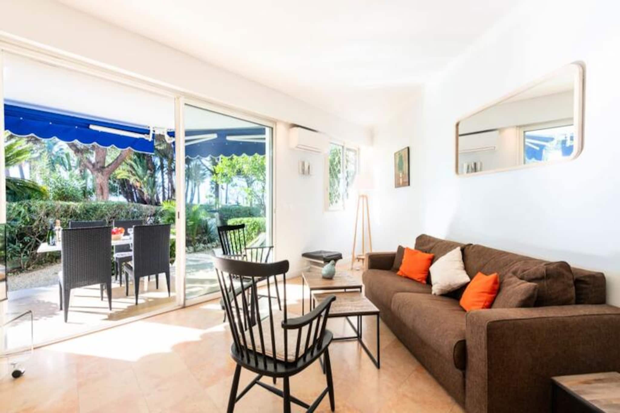 Step into a world of elegance and coastal charm with this ground-floor apartment in Cannes’ prestigious Palm Beach district. Perfectly positioned on the iconic Croisette, this property offers direct access to the beaches and port, allowing you to immerse yourself in the vibrant allure of the French Riviera. The private landscaped garden, a serene oasis amidst the lively surroundings, invites you to unwind in style, whether basking in the sun or enjoying al fresco dining under the Mediterranean sky. \n\nInside, the apartment is thoughtfully designed to combine comfort and sophistication. The air-conditioned living room, adorned with large bay windows, opens onto the lush garden, creating a seamless indoor-outdoor experience. The fully equipped kitchen makes meal preparation a delight, while the master suite, featuring a king-size bed and en-suite bathroom, promises restful nights. A second bedroom and additional amenities, such as Wi-Fi and reversible air conditioning, ensure a relaxing stay for all. \n\nJust steps away, the Croisette beaches beckon, offering golden sands and sparkling waters. Explore the nearby Old Port or wander through the historic streets of Le Suquet for panoramic views of Cannes. Luxury boutiques, the Palais des Festivals, and the bustling Forville Market are all within easy reach, while water sports and boat trips provide endless opportunities for adventure. \n\nWhether you’re seeking a romantic getaway or a family retreat, this apartment is your gateway to the glamour and tranquility of Cannes. With its prime location, private garden, and modern comforts, it’s the perfect base for creating unforgettable memories on the French Riviera.
