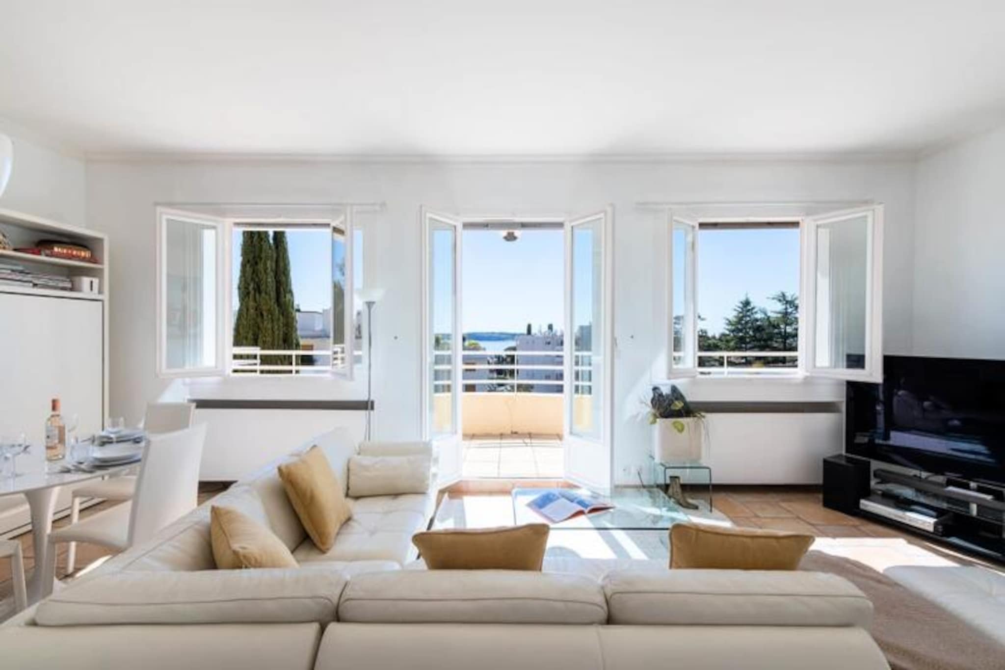 High above the glamorous streets of Cannes, this exquisite top-floor apartment in a historic villa offers an unparalleled retreat for those seeking both tranquility and sophistication. Imagine waking up to the gentle Mediterranean breeze, with panoramic views stretching from the azure sea to the iconic Lérins Islands, all from your private rooftop terrace. This serene escape is just minutes from the vibrant heart of Cannes, yet feels worlds away in its peaceful residential setting. 
 
 Step inside and be greeted by a light-filled living room, where a south-facing aspect bathes the space in sunshine. The elegant leather sofa and dining area create a welcoming ambiance, while the fully equipped kitchen opens onto a charming conservatory, perfect for morning coffee or quiet reflection. Outside, the private garden beckons with its intimate swimming pool, sun loungers, and shaded dining area under swaying palm trees. For the ultimate indulgence, ascend to the rooftop terrace, where an outdoor lounge and daybed invite you to soak in the breathtaking views. 
 
 The apartment comfortably accommodates up to four guests with two beautifully appointed bedrooms. The master suite features an en-suite bathroom, while a second double bedroom and additional shower room ensure convenience and privacy. Modern amenities such as high-speed Wi-Fi, reversible air conditioning, and a private elevator enhance your stay.
 
 Perfectly situated, this property places you close to Cannes’ most iconic attractions. Stroll along the Boulevard de la Croisette, explore the cobbled streets of Le Suquet, or unwind on the sandy shores of Gazagnaire Beach. Whether you’re here for the film festival, luxury shopping, or simply to relax, this apartment offers a refined base to experience the best of the French Riviera.