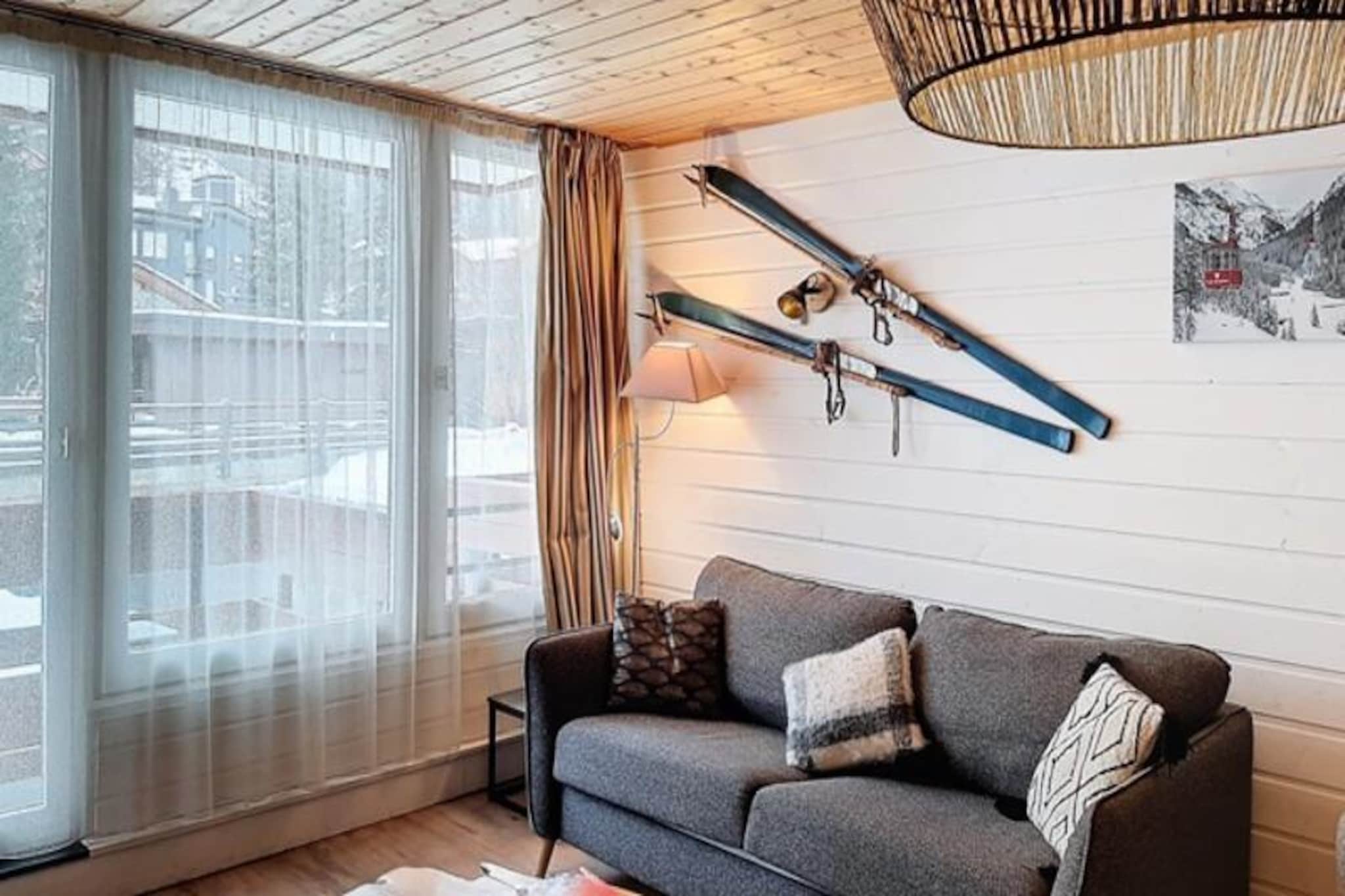 Imagine waking up in the heart of the Alps, where the crisp mountain air and the soothing sound of a river greet you each morning. This cozy 22 m² studio apartment, nestled in the Le St Charles residence, offers an inviting retreat for up to four guests. Perfectly situated in the center of the resort and just steps away from the ski slopes, it’s an ideal base for both winter sports enthusiasts and summer adventurers alike. The west-facing ground-floor balcony provides a serene view of the river, creating a tranquil space to unwind after a day of exploration. \n\nInside, the apartment is thoughtfully designed for comfort and functionality. The living room features a sofa bed, a dining area, and a well-equipped kitchenette with a ceramic hob and dishwasher, ensuring you have everything you need to prepare meals with ease. A sleeping alcove with two bunk beds offers a cozy space for additional guests. The bathroom, complete with a toilet, is modern and convenient. For your entertainment, a television is provided, subject to digital terrestrial reception. \n\nGuests can enjoy exclusive winter perks, including preferential rates on Tignes and Val d'Isère ski passes, making this location a haven for skiers. Additional services such as parking, Wi-Fi, and cleaning can be arranged to ensure a hassle-free stay. \n\nWhether you're here to carve through pristine slopes or to bask in the beauty of the alpine summer, this centrally located retreat offers the perfect blend of comfort, convenience, and charm. Your alpine escape awaits!