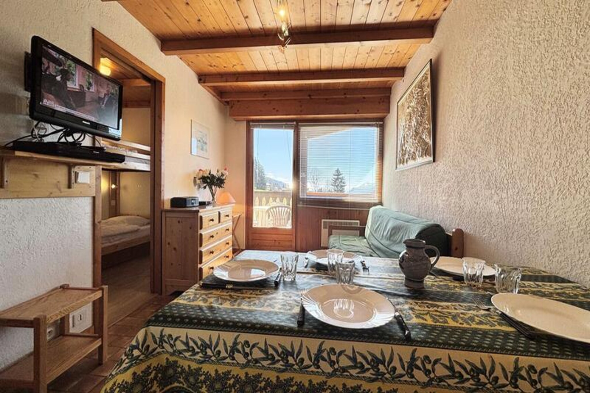 At the foot of the majestic French Alps, this charming ground-floor apartment offers a cozy retreat for your next mountain getaway. Surrounded by serene landscapes and just steps from the slopes, it’s the perfect base for both winter sports enthusiasts and summer adventurers. Wake up to crisp alpine air and enjoy the tranquility of this peaceful location, where the beauty of nature meets the comfort of modern living. Whether you're here for skiing, hiking, or simply unwinding, this residence promises a memorable stay. \n\nThe apartment spans 30 m² and is thoughtfully designed to maximize space and comfort. It features a welcoming living room with a pull-out sofa bed, a kitchenette equipped for preparing hearty meals, a bedroom with a double bed, and a sleeping alcove with two bunk beds. Please note that the upper bunk is not suitable for children under six. A shower room, separate toilet, and a private balcony complete the layout, offering a practical yet inviting space for up to five guests. Additional amenities include a ski locker and a private covered parking space, ensuring convenience throughout your stay. \n\nLocated in a quiet area, the residence provides easy access to the slopes, making it ideal for ski lovers. The nearby toboggan run adds a touch of fun for families, while the surrounding trails invite exploration during the warmer months. For added ease, optional services such as bed linen, towels, and end-of-stay cleaning are available upon request. Pets are welcome for a small fee, allowing you to bring your furry companions along for the adventure. \n\nWhether you’re seeking thrilling alpine activities or peaceful moments in nature, this apartment offers an inviting escape in the heart of the French Alps. Book your stay and create unforgettable memories in this picturesque mountain haven.