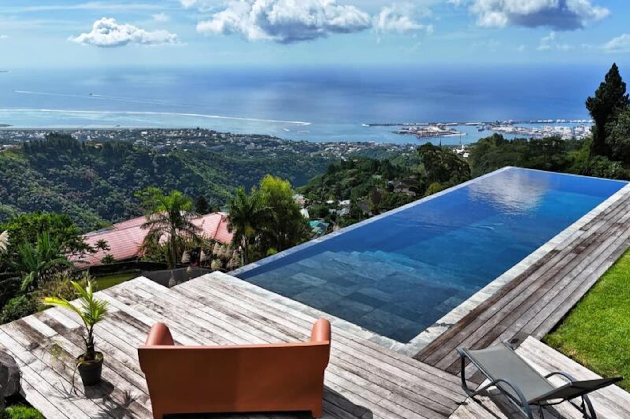 High above the vibrant city of Papeete, this private guesthouse offers an unparalleled retreat surrounded by dramatic rocky landscapes and lush tropical greenery. With sweeping views of Moorea Island and the endless Pacific Ocean, this haven is a perfect blend of tranquility and natural beauty, ideal for those seeking a serene escape. The setting, perched on the grounds of an architect-designed villa, immerses you in the unique charm of French Polynesia while ensuring complete privacy and comfort. \n\nThe guesthouse, a cozy 27 m² annex, is thoughtfully designed to cater to your every need. It features a plush king-size bed, a fully equipped kitchen, and a sleek, modern bathroom with a shower, vanity, and toilet. Step out onto your private terrace to take in the breathtaking views, or enjoy direct access to the stunning infinity pool, where the ocean and sky seem to merge into one. The shared outdoor spaces, including the pool, garden, and terrace, are meticulously maintained and provide the perfect backdrop for relaxation. \n\nWhile the owner resides in the main villa, their presence is discreet, ensuring your peace and quiet. On occasion, you may meet their two friendly dogs, who are gentle and affectionate. For your comfort, they are kept in their kennel when the owner is away. Please note that due to the open pool design, this accommodation is reserved for guests aged 15 and above. \n\nThis rare gem, suspended between sea, sky, and mountain, invites you to experience the essence of French Polynesia. Whether you’re savoring the panoramic views, exploring the vibrant culture of Papeete, or simply unwinding in the serene surroundings, every moment here is a celebration of nature and beauty.