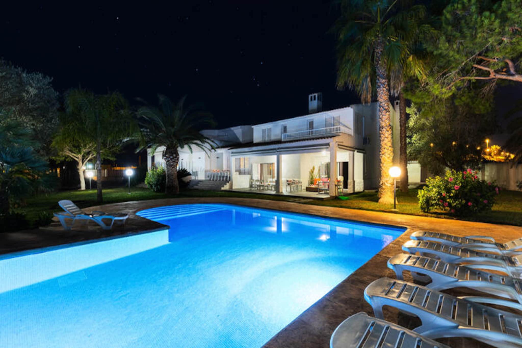 Imagine a serene escape just five minutes from the charming coastal town of Santa Pola, where this stunning villa offers an oasis of relaxation and entertainment. Surrounded by lush gardens and a private pine forest, this property is a haven for those seeking tranquility and unforgettable moments with loved ones. Whether you're lounging by the sparkling private pool or enjoying a friendly match on the tennis court, this villa promises a holiday filled with joy and comfort. The barbecue area and spacious outdoor seating make it perfect for al fresco dining under the warm Spanish sun.
Inside, the villa is designed with both luxury and functionality in mind. The ground floor boasts a fully equipped kitchen with an island and dining area, a cozy living room with a fireplace, a games room, and two inviting bedrooms. Upstairs, you'll find five additional bedrooms, many with en-suite bathrooms and balconies that overlook the picturesque gardens. With air conditioning and ceiling fans throughout, every corner of the villa ensures a cool and comfortable retreat even on the hottest days. The property also features a covered garage and ample parking space for up to 10 vehicles, making it ideal for larger groups.
Santa Pola’s golden beaches, vibrant marina, and lively markets are just a short drive away, offering endless opportunities for exploration and adventure. For nature enthusiasts, the nearby salt flats and birdwatching spots provide a unique glimpse into the region’s natural beauty. Whether you're planning a family holiday, a getaway with friends, or a special celebration, this villa is the perfect backdrop for creating cherished memories. Book your stay today and experience the best of Spain’s Costa Blanca.
