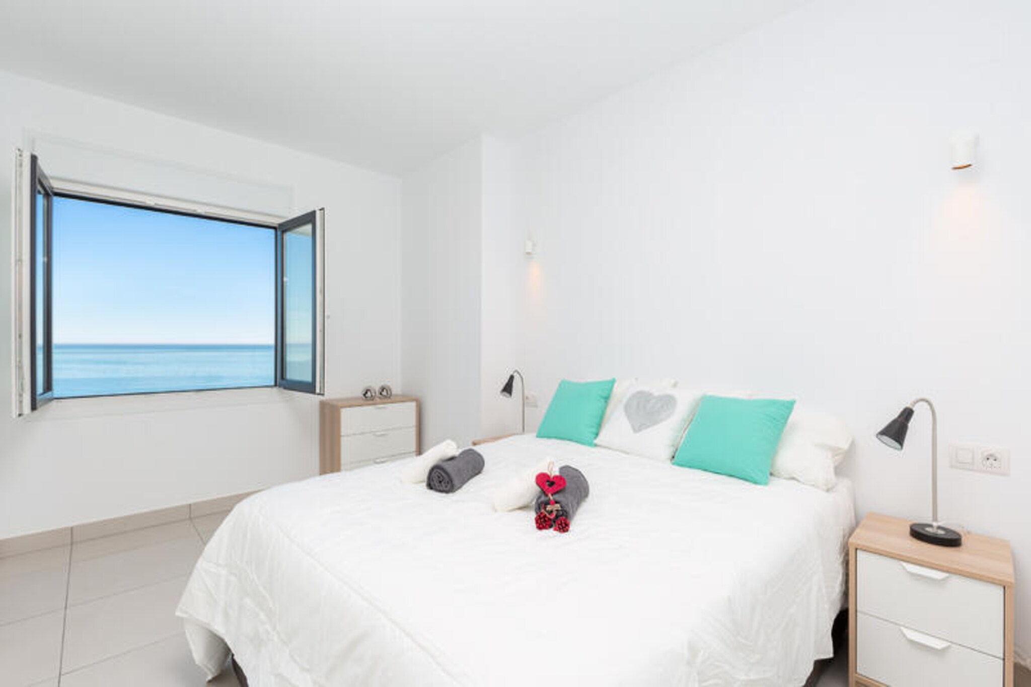 Where the azure waters of the Mediterranean meet golden sands, this luxurious beachfront apartment in Punta Prima offers a haven of tranquility and elegance. From the moment you step inside, you are greeted by breathtaking sea views that stretch endlessly from every room, immersing you in the beauty of coastal Spain. Whether you're sipping your morning coffee on the private balcony or watching the sun dip below the horizon, every moment here feels like a postcard come to life.
The apartment is designed with contemporary sophistication, comfortably accommodating up to six guests. The spacious living room, bathed in natural light from floor-to-ceiling windows, is a perfect blend of style and comfort. The fully equipped kitchen, complete with state-of-the-art appliances and high-quality utensils, invites you to create culinary delights while enjoying the mesmerizing sea views. Three beautifully appointed bedrooms, including a master suite with an en-suite bathroom, ensure restful nights, with large windows allowing you to wake up to the soothing sight of the Mediterranean. Air conditioning in every room guarantees comfort no matter the season.
Step outside, and you'll discover a world of relaxation within the residential complex. The meticulously landscaped communal gardens provide a serene escape, while the shared swimming pool offers a refreshing retreat under the warm Spanish sun. For added convenience, the property includes a secure garage, ensuring peace of mind throughout your stay.
Perfectly positioned in Punta Prima, this apartment is not just a place to stay but an experience to cherish. Whether you're here for a romantic getaway, a family retreat, or simply to bask in the beauty of the Mediterranean, this luxurious beachfront escape promises memories that will last a lifetime.