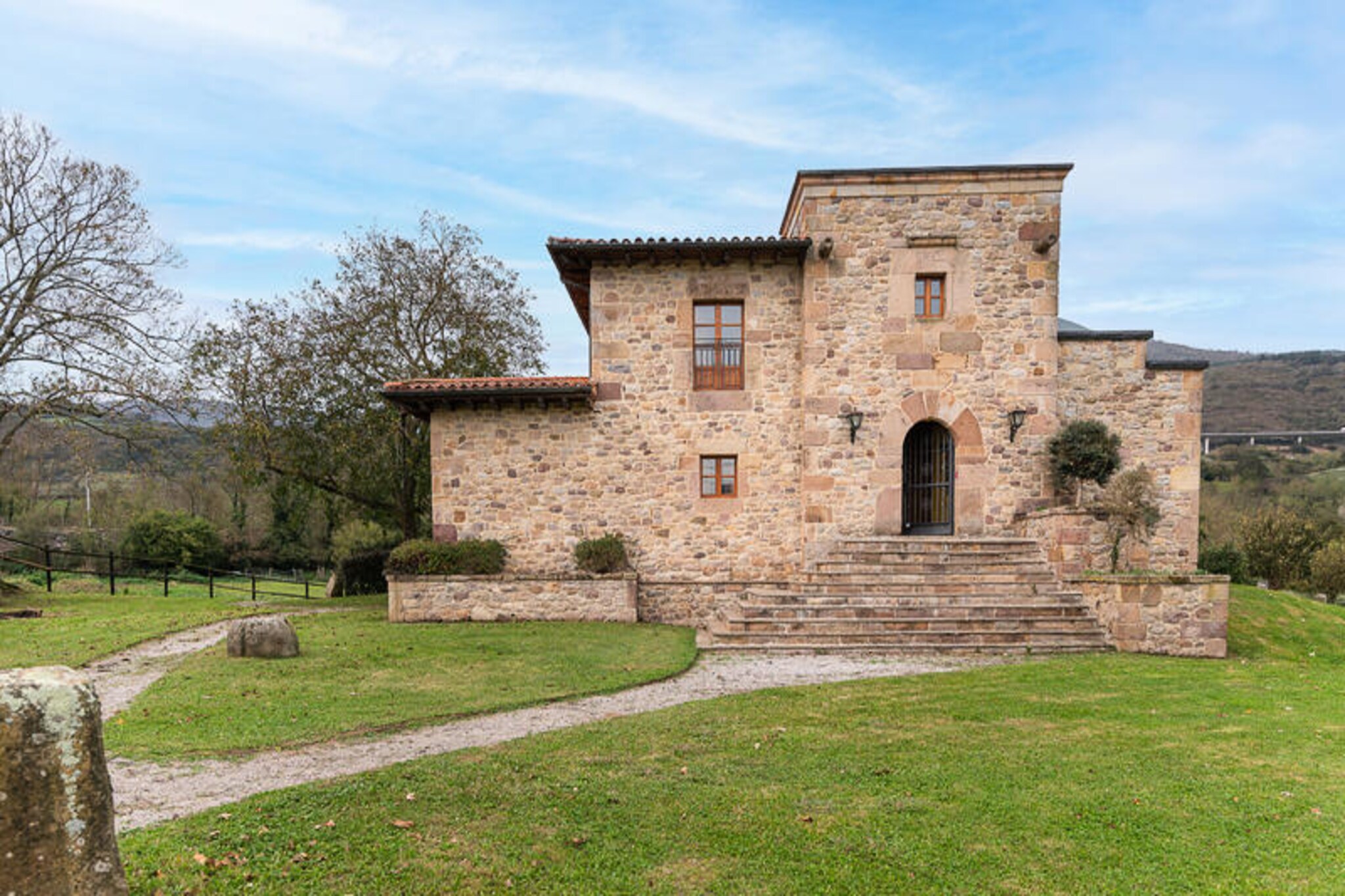 In the heart of the serene Iguña Valley, where rolling green mountains meet lush forests, this remarkable stone house offers a tranquil escape steeped in history and charm. Set on an expansive 10,000 m² plot, the property boasts breathtaking panoramic views of the surrounding Cantabrian landscape, inviting you to immerse yourself in nature’s beauty while enjoying the comforts of modern living. 
 
 Lovingly constructed with recycled materials from historic ruins, this home exudes character and authenticity. Inside, natural light floods the spacious interiors, creating a warm and welcoming atmosphere. The ground floor features a grand entrance hall, a cozy living and dining area, a fully equipped kitchen with direct terrace access, and a double bedroom with its own terrace and en-suite bathroom. Upstairs, three generously sized bedrooms and a full bathroom provide ample space for families or groups. The kitchen, complete with modern appliances and a large dining table, opens onto a covered terrace, perfect for al fresco meals.
 
 Surrounded by a vast garden, the property offers a peaceful retreat where horses graze on neighboring land, enhancing the idyllic rural setting. Despite its secluded feel, the house is conveniently located just 180 meters from a train stop, providing easy access to Cantabria’s highlights. Explore the pristine beaches of Usgo, Tangle, or Liencres, or visit cultural gems like Santander and Santillana del Mar, all within a 40-minute drive. Nature lovers will delight in nearby hiking trails through the Saja Besaya Natural Park and around the Alsa and Ebro dams.
 
 Whether you’re seeking outdoor adventure or a serene getaway, this unique property in Barcena de Pie de Concha promises an unforgettable stay in the heart of Cantabria’s natural splendor.