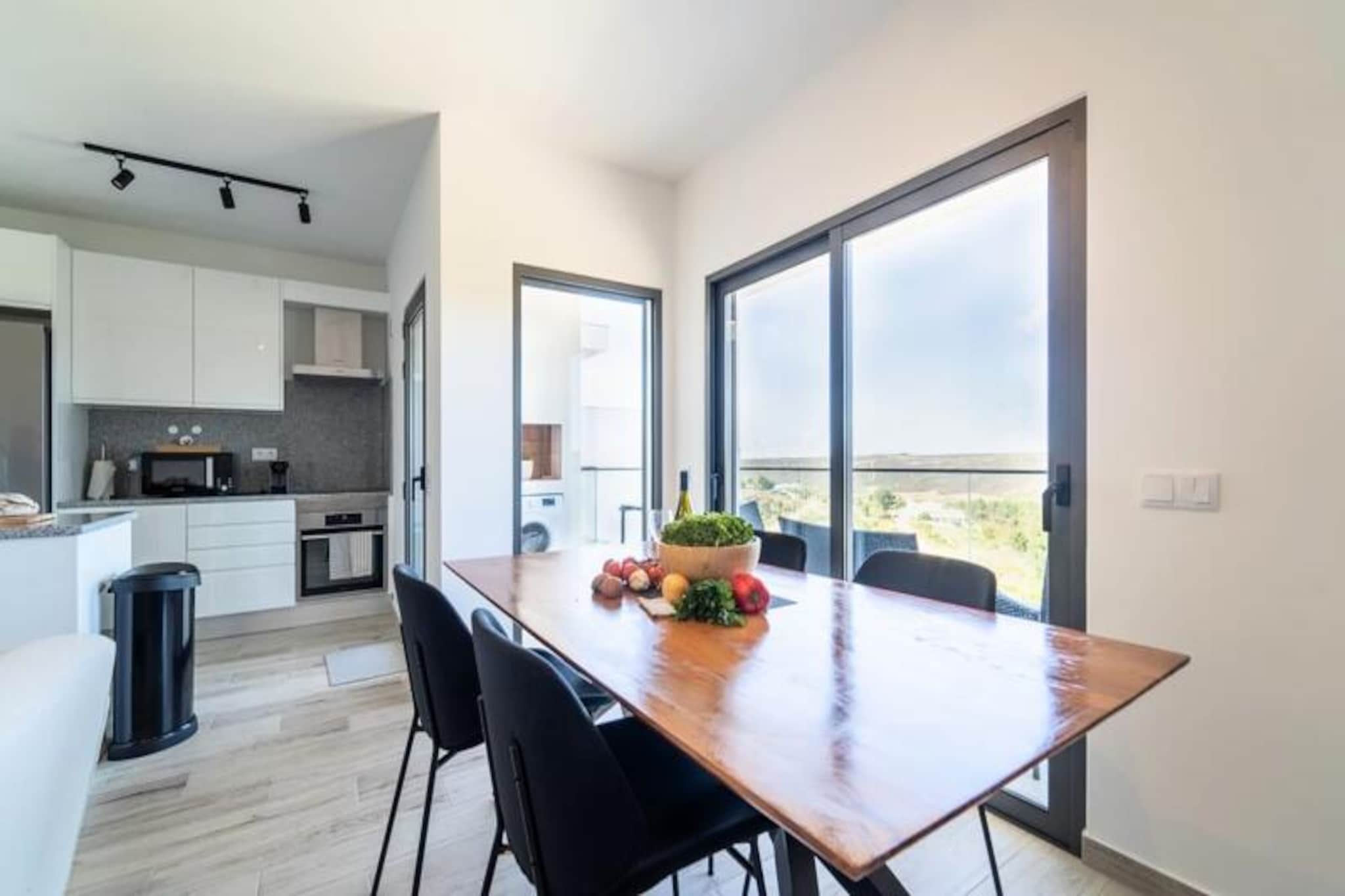 Awaken your senses in this serene 2-bedroom, 2-bathroom apartment perched on the edge of Portugal’s breathtaking Costa Vicentina Natural Park. With panoramic views of the Amoreira River and wetlands, this retreat offers a perfect blend of tranquility and natural beauty. Just a short walk from the Blue Flag-awarded Monte Clérigo Beach and the pristine Amoreira Beach, you’ll find yourself immersed in the unspoiled charm of the Algarve’s west coast. Whether it’s the golden glow of sunrise or the fiery hues of sunset, the two terraces provide a front-row seat to nature’s daily spectacle. \n\nInside, the apartment is thoughtfully designed for comfort and style. The master bedroom features an en-suite bathroom complete with a bathtub and bidet, while both bedrooms are adorned with queen-size beds, luxurious Portuguese linens, and original artwork by a local artist. The living room invites relaxation with its plush sofa bed and 50\